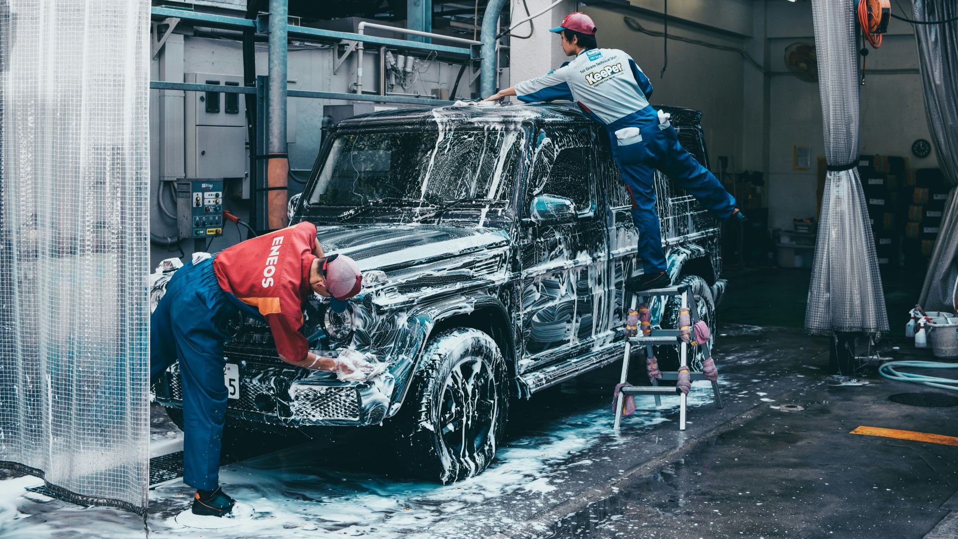two men washing black SUV