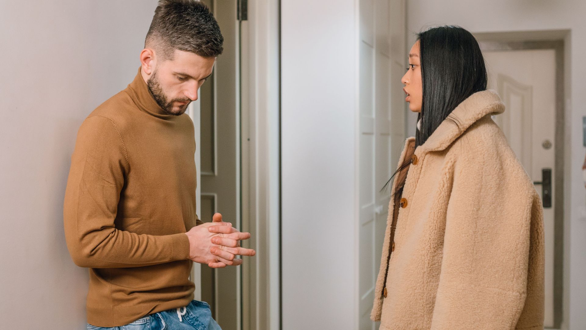 A man and woman having a serious discussion indoors, portraying relationship tension.