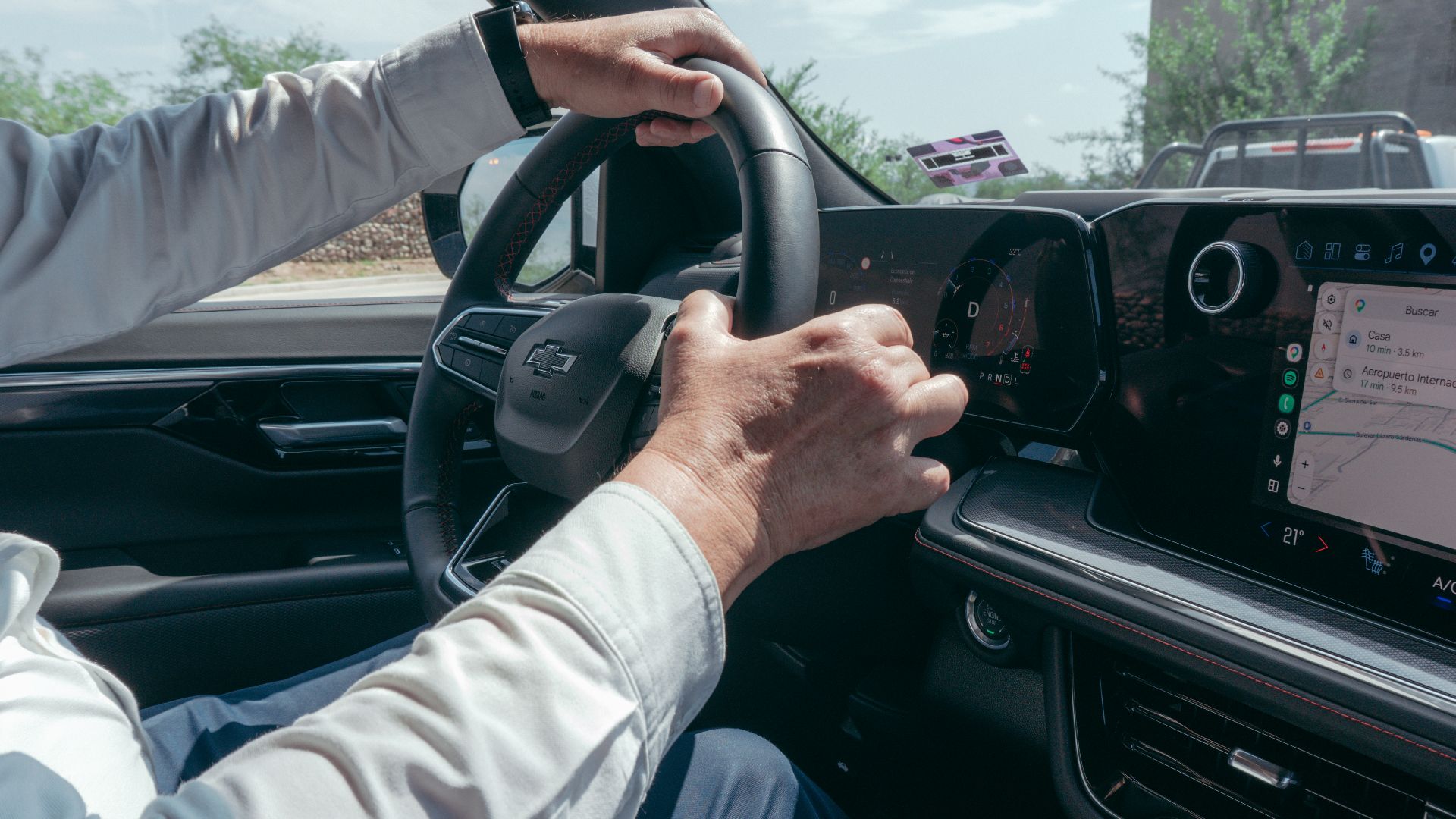A person driving a modern car while using the built-in GPS navigation system.
