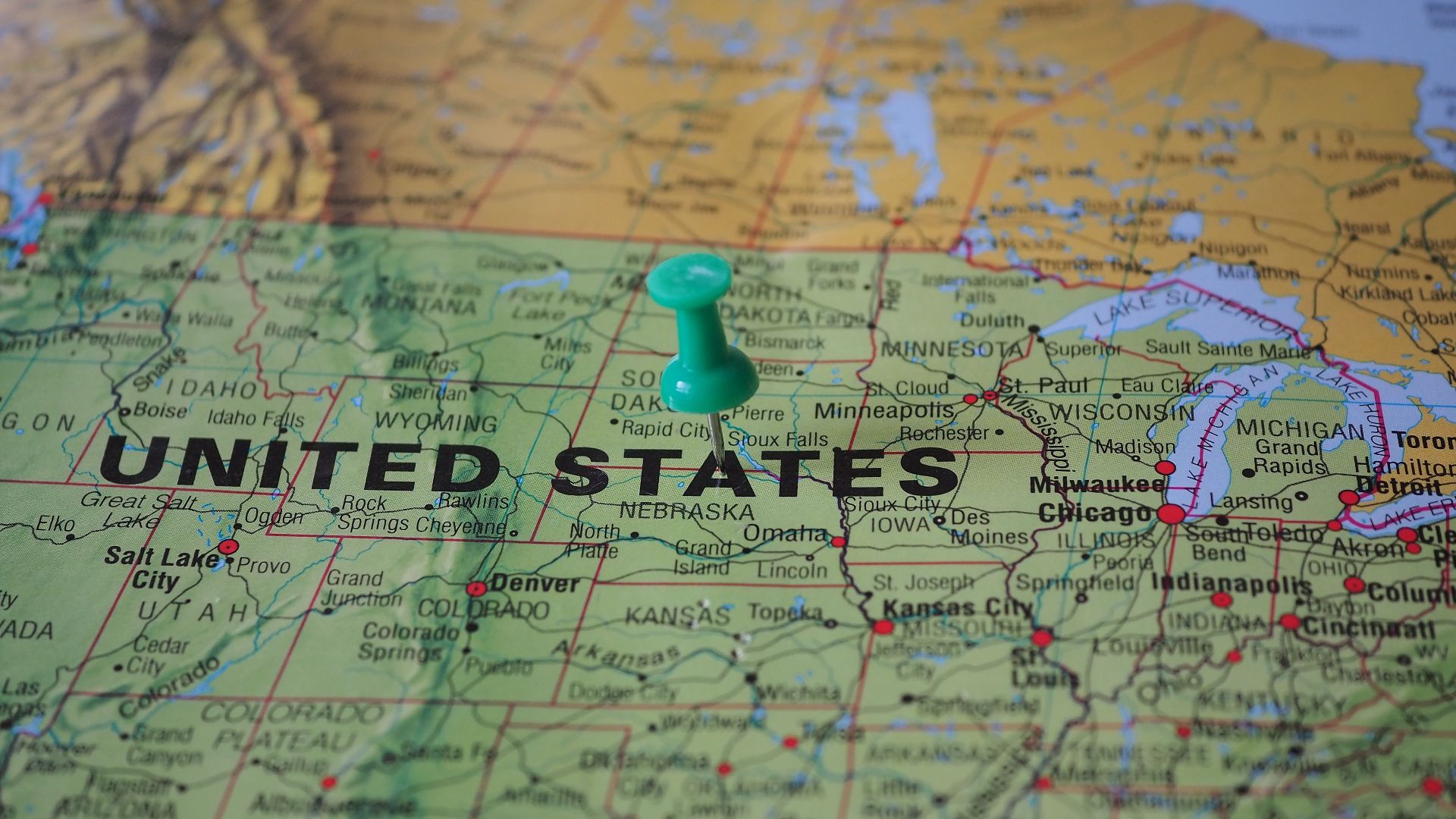 High-angle view of a map featuring the United States with a green pin indicating a specific location.