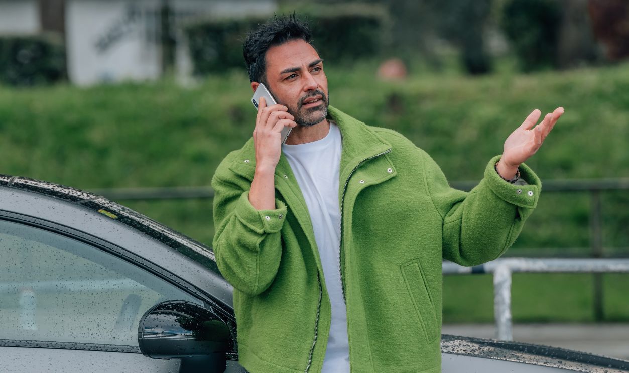 bearded man outdoors with mobile phone in the car