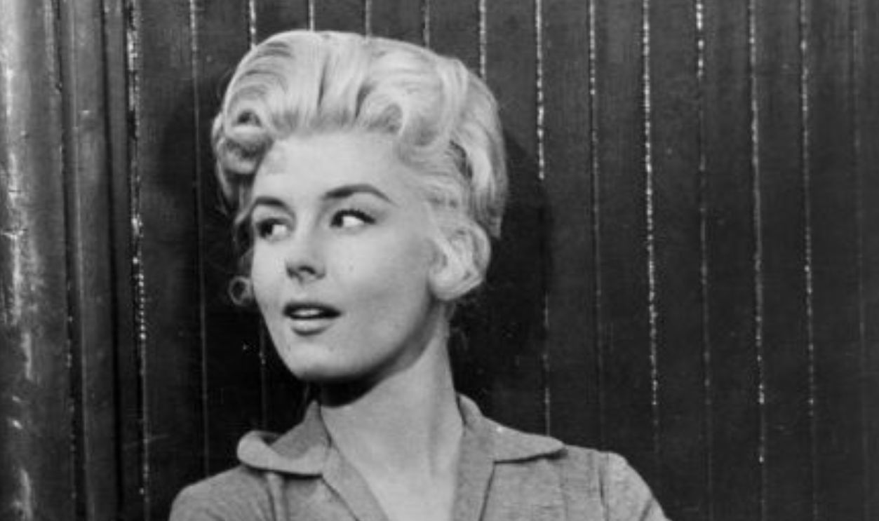 1957: Actress Elaine Stewart teases Audie Murphy (1924-1971) in a scene from the Universal-International Technirama action thriller 'Night Passage'.