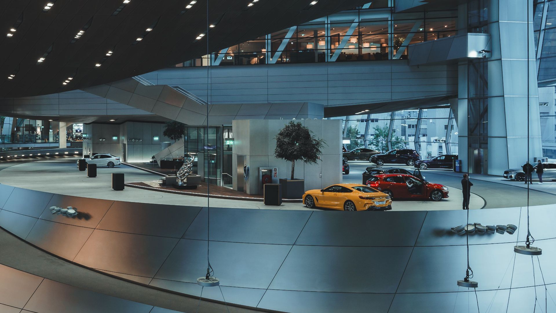 Interior view of BMW Welt showcasing sleek design and luxury cars in Munich, Germany.