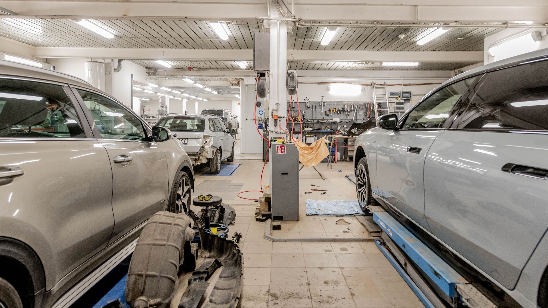 Interior of an automotive repair shop with cars undergoing maintenance and servicing.