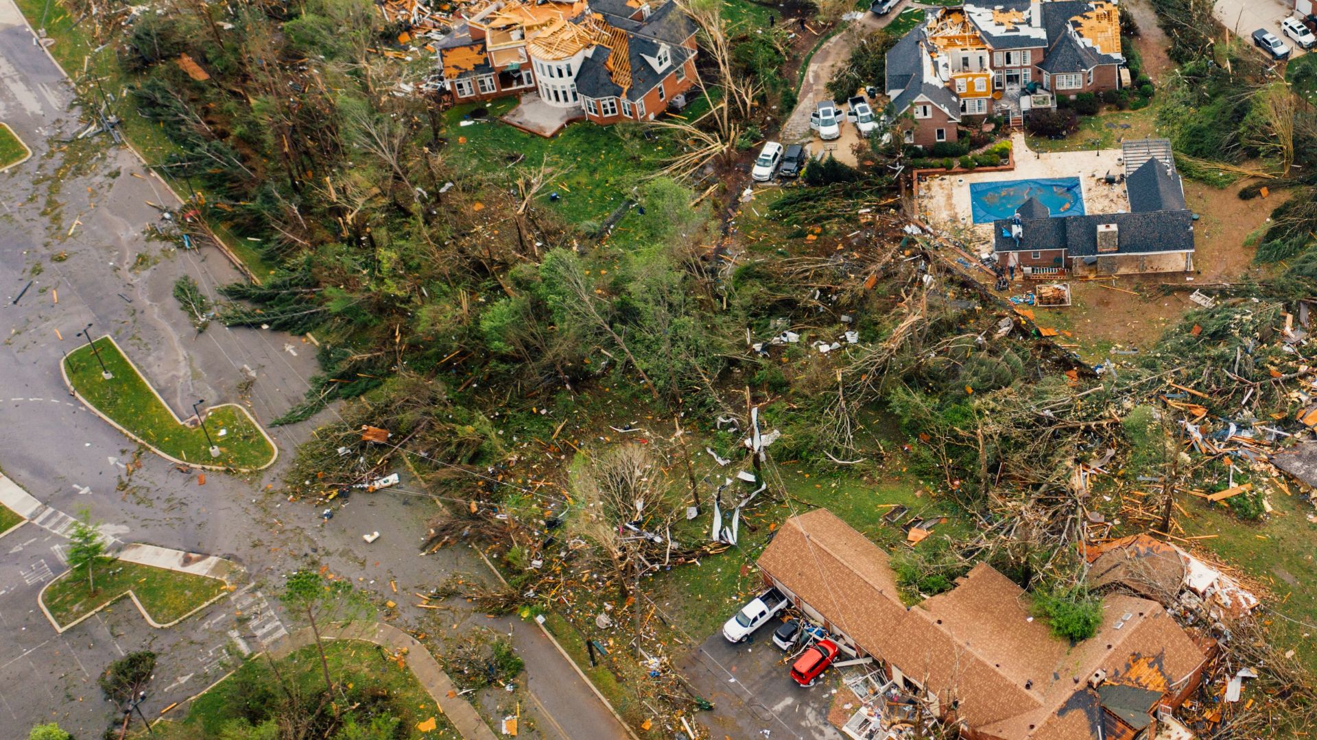Aerial view of small settlement with destroyed houses and bent uprooted trees after hurricane
