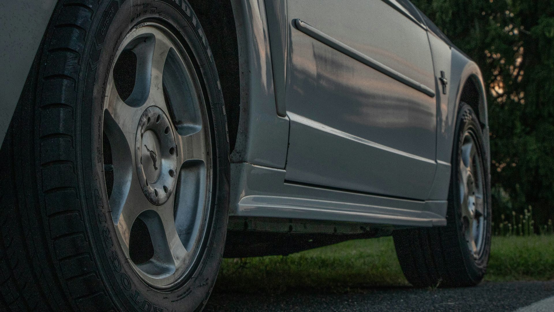 Close-up view of a gray vehicle's wheels and side
