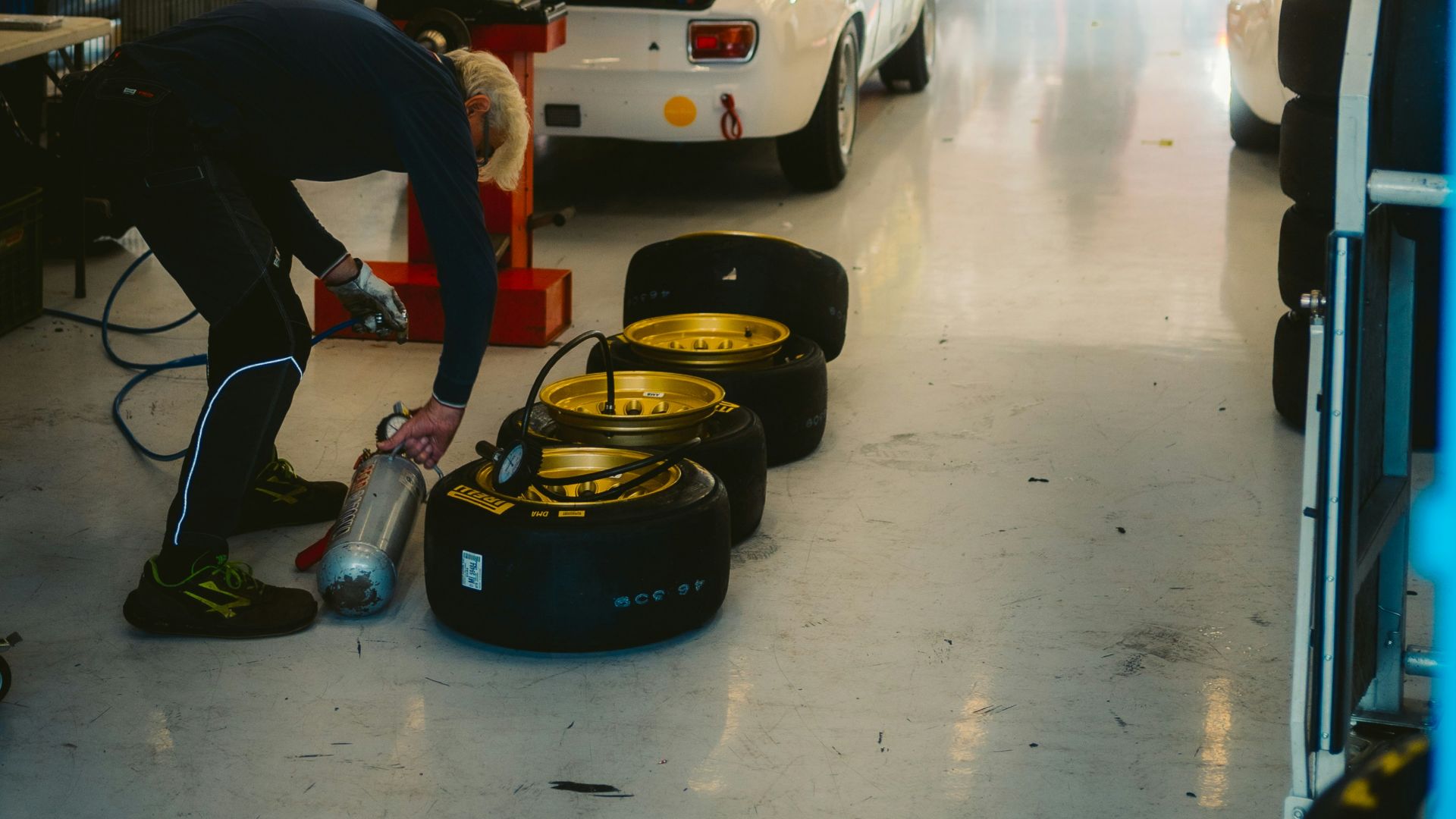 Race cars being serviced in a garage pit stop