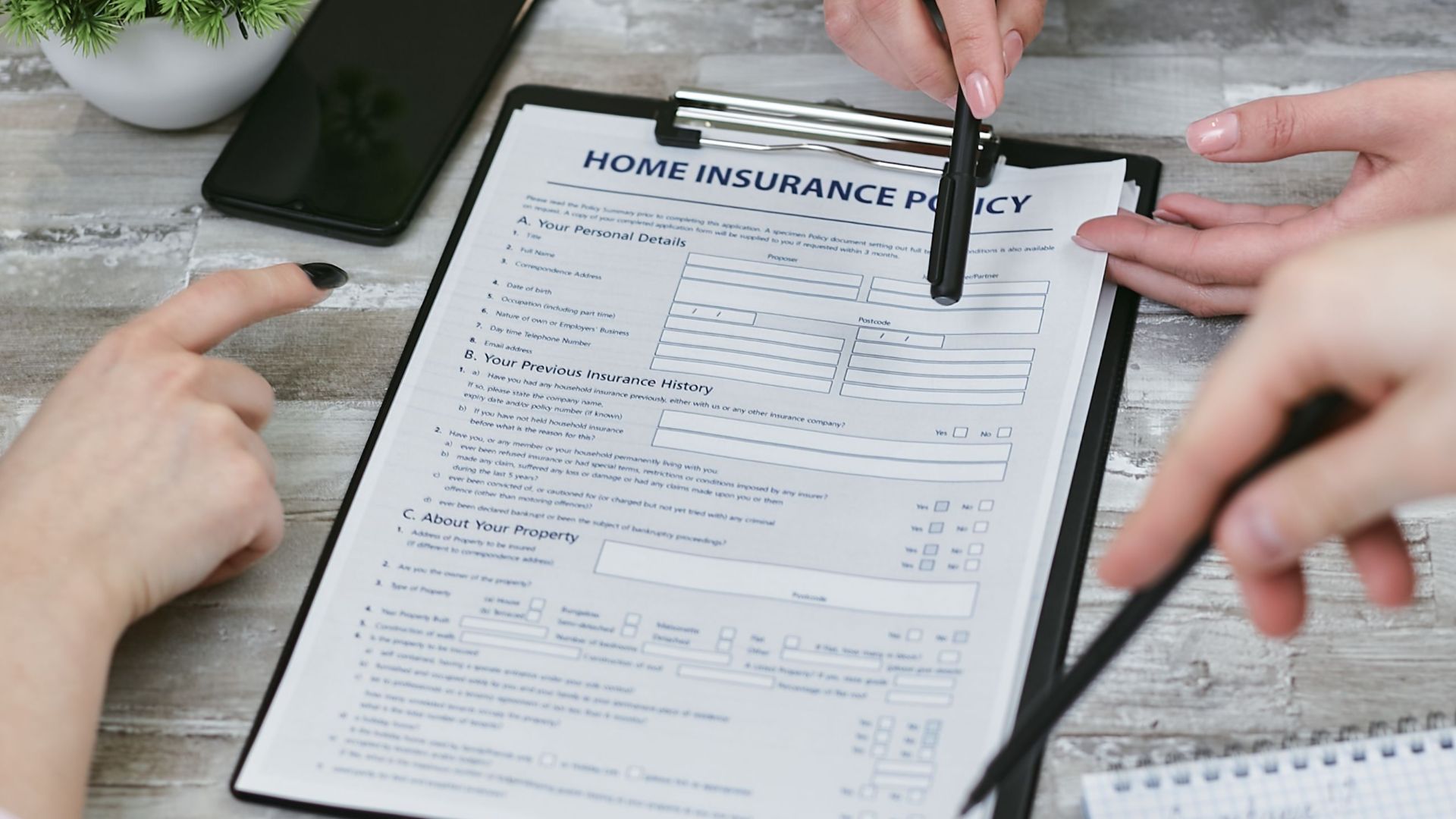 Three individuals collaborating on a home insurance policy document. Elements include a clipboard, notes, and pointing hands.