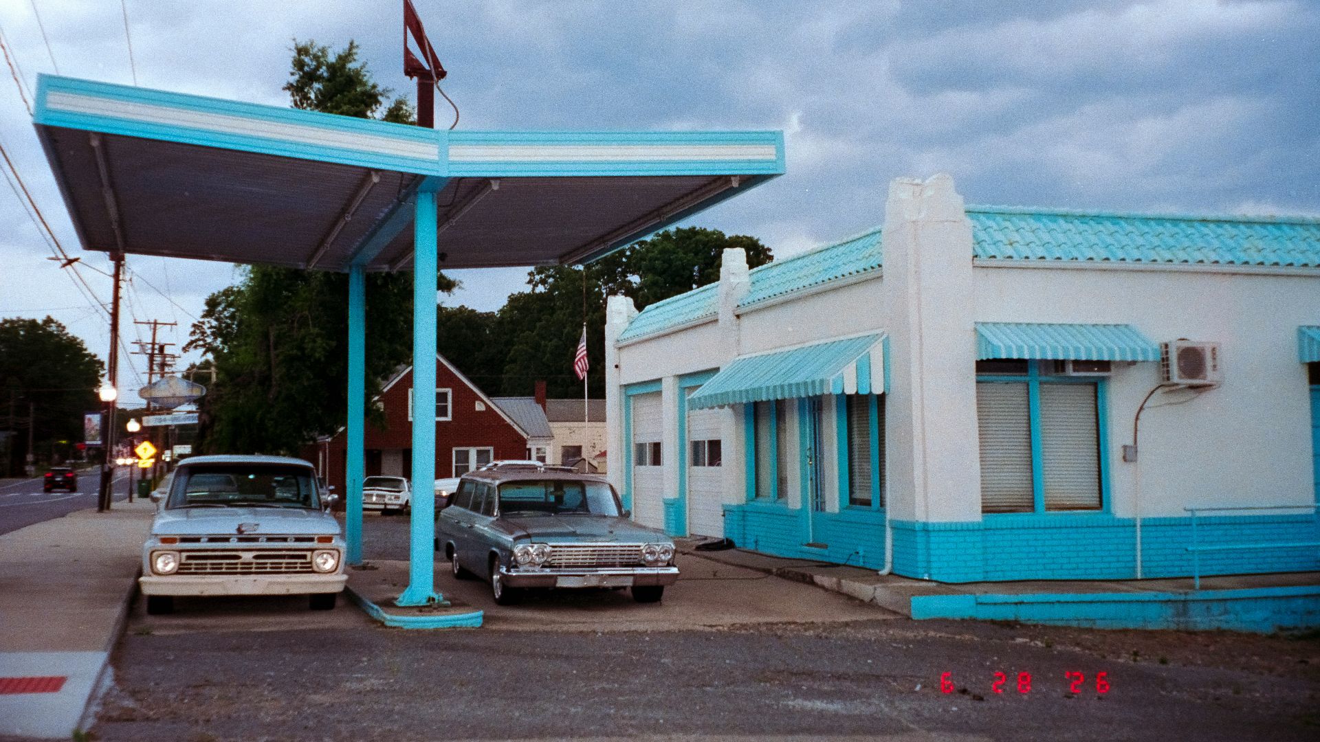 Vintage gas station and cars under blue canopy