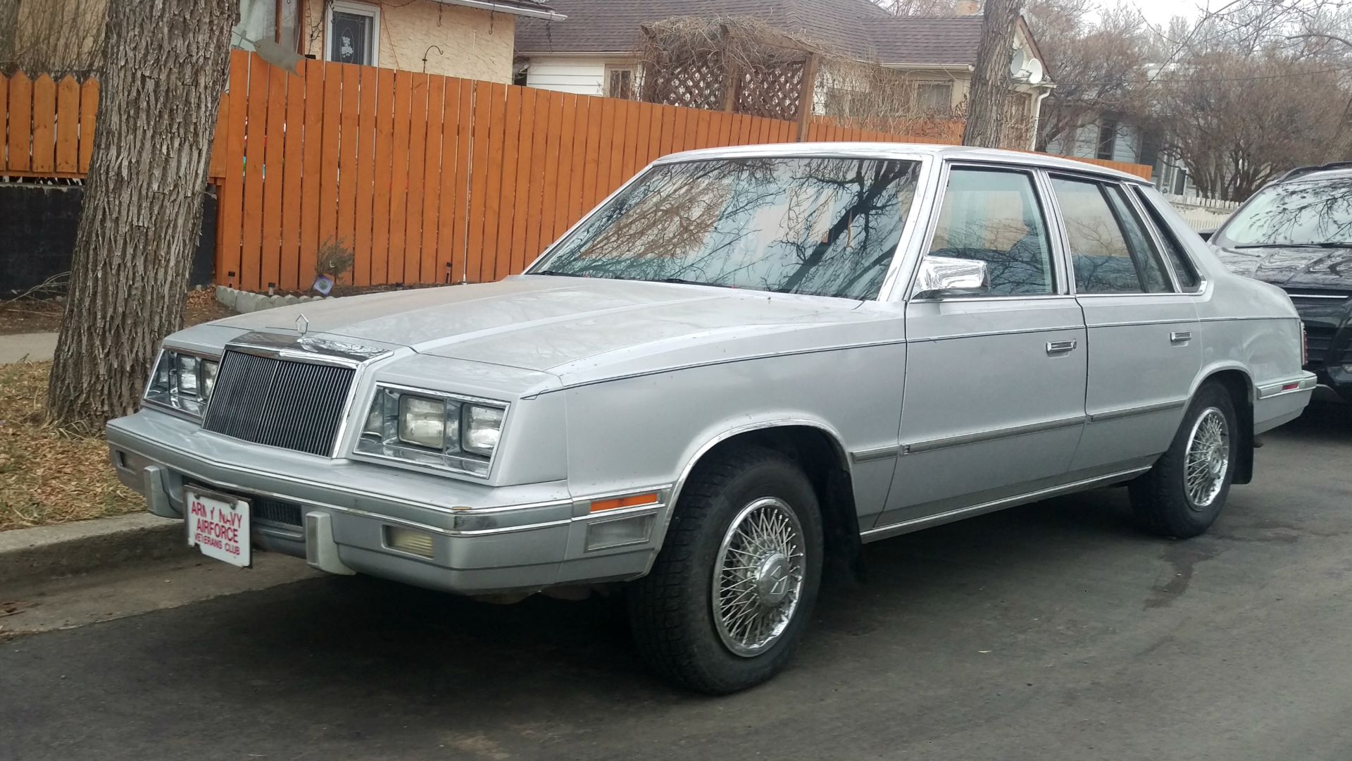 The Chrysler E-Class is a K-car variant just below the New Yorker in equipment and price. I believe this is an 1984 model with the revised tail lights but still retaining the stand up hood badge.  One of 32,237 made for that year.