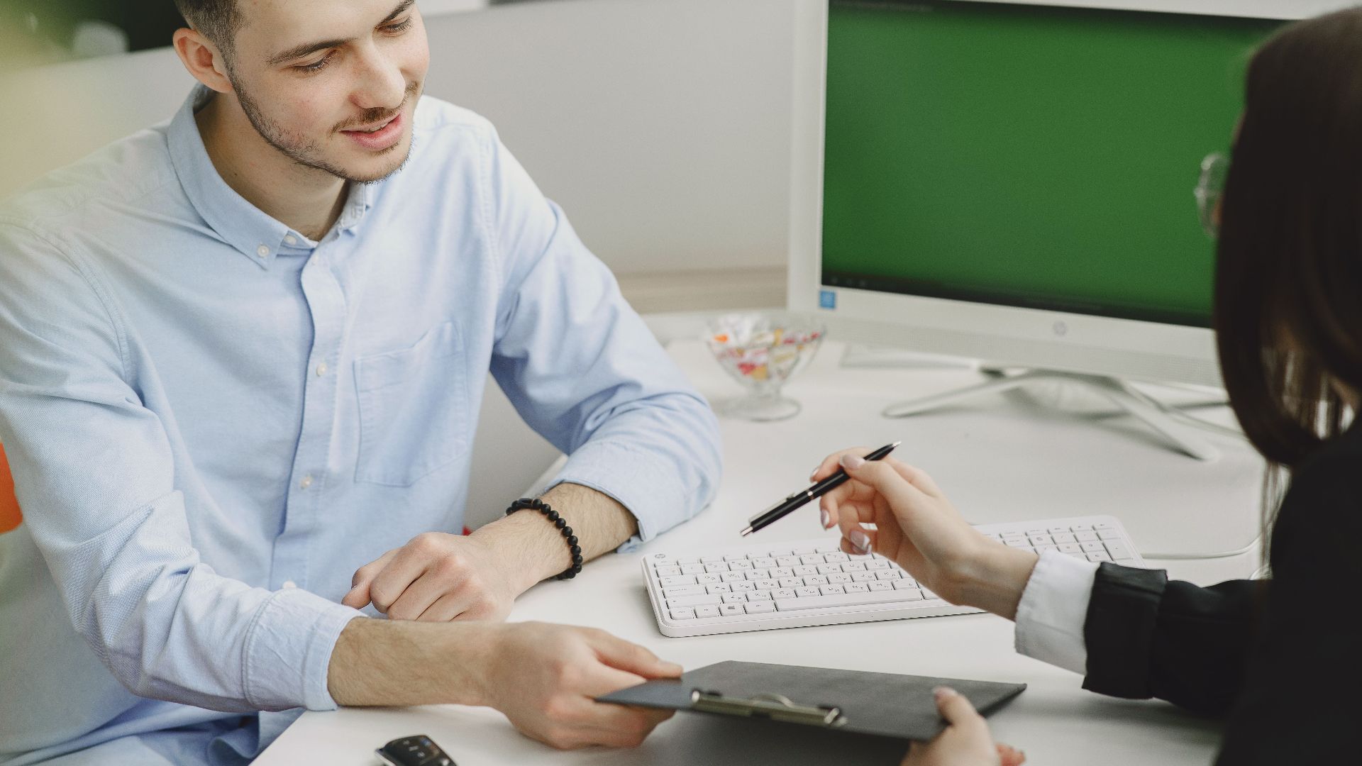 Colleagues discussing project details at a modern office desk