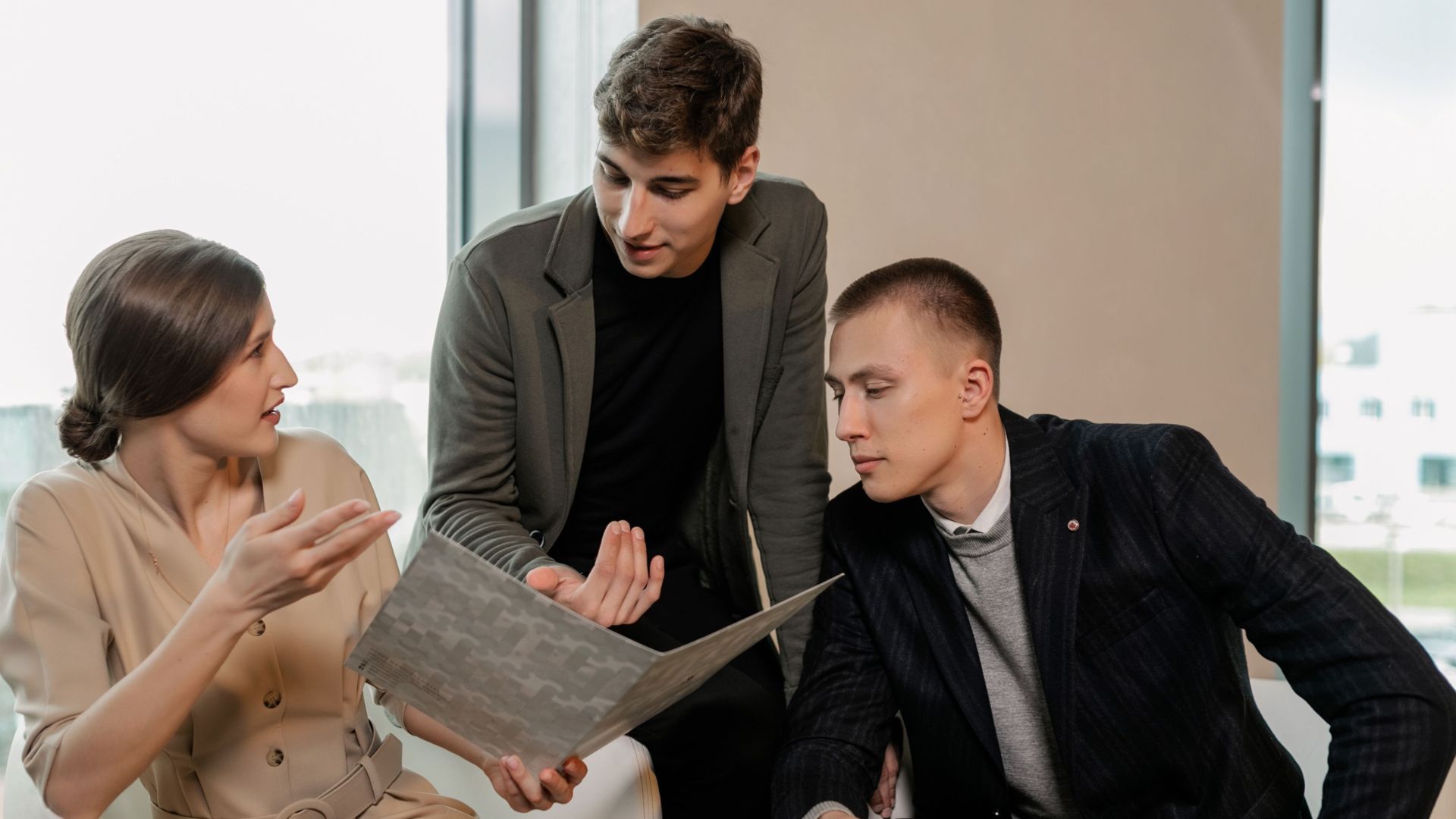 Group of professionals discussing business strategy together inside a modern office.