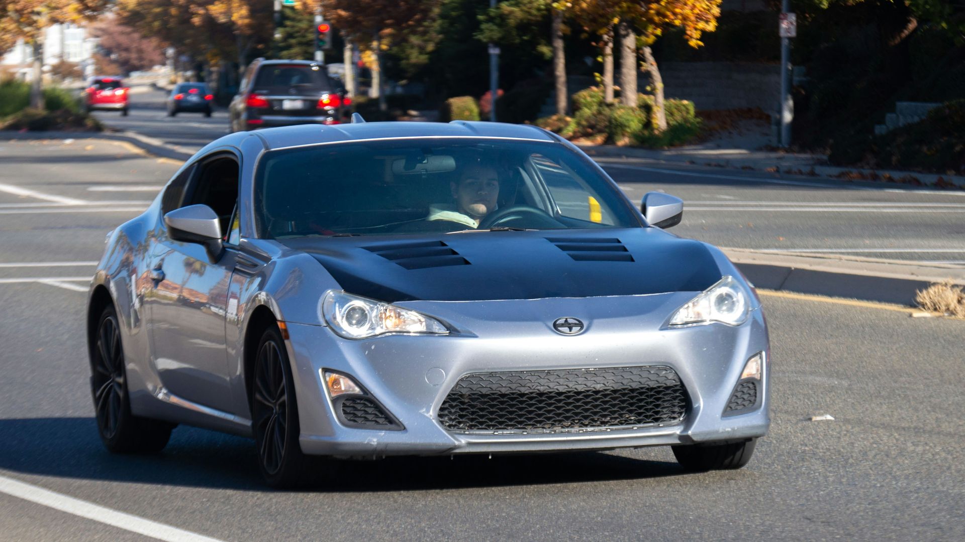 a silver car driving down the road
