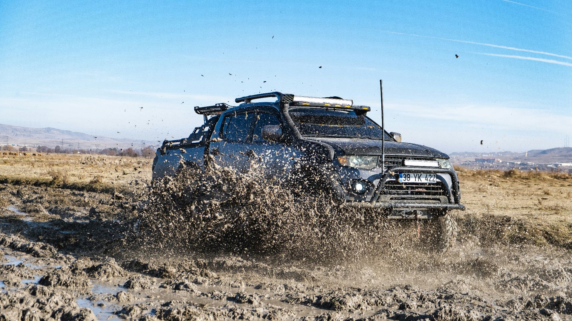 a truck driving through mud in the desert