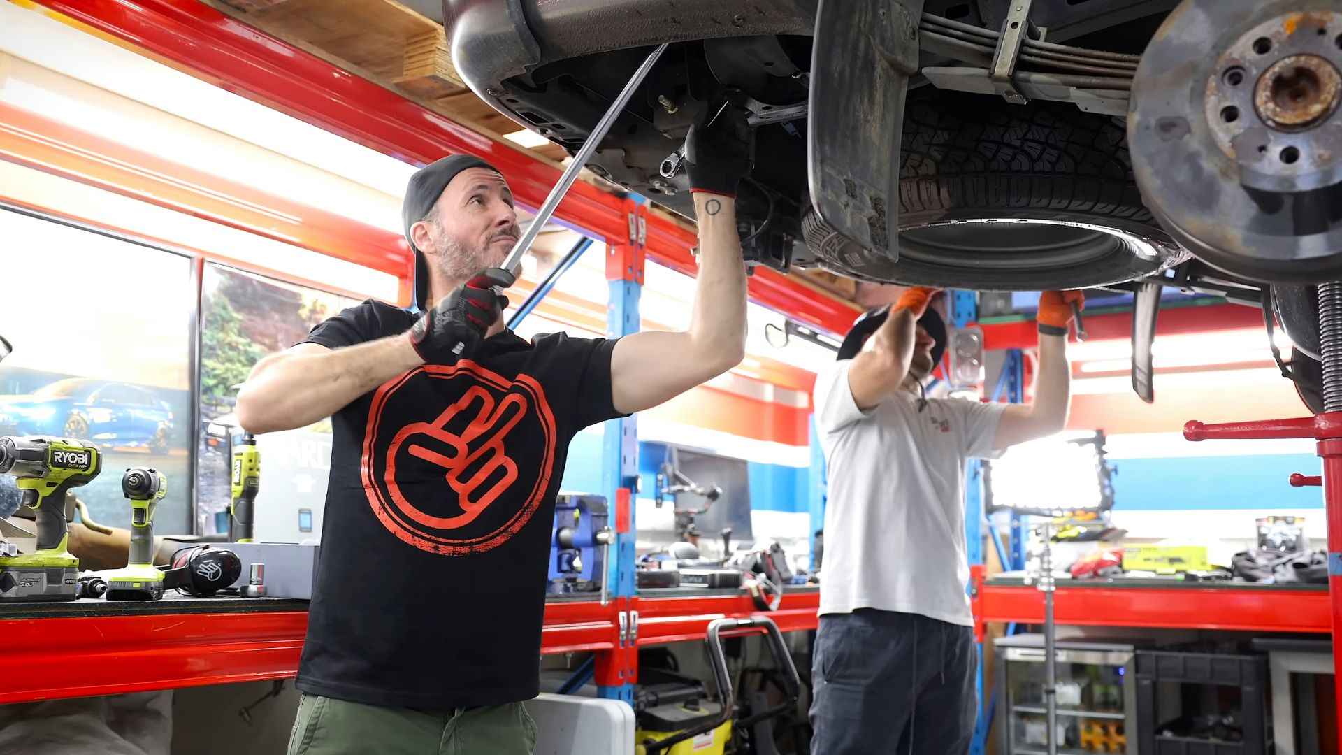 Two men working on a car in a garage