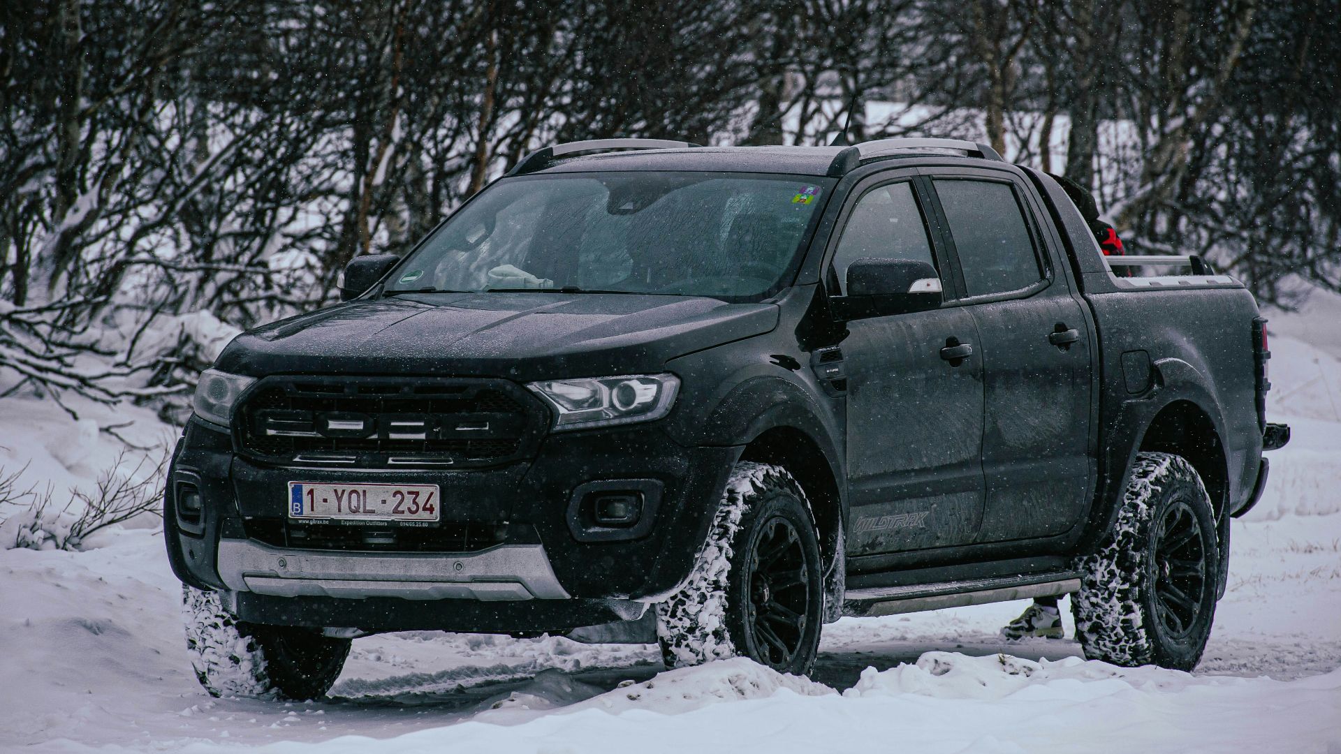 a black truck is parked in the snow