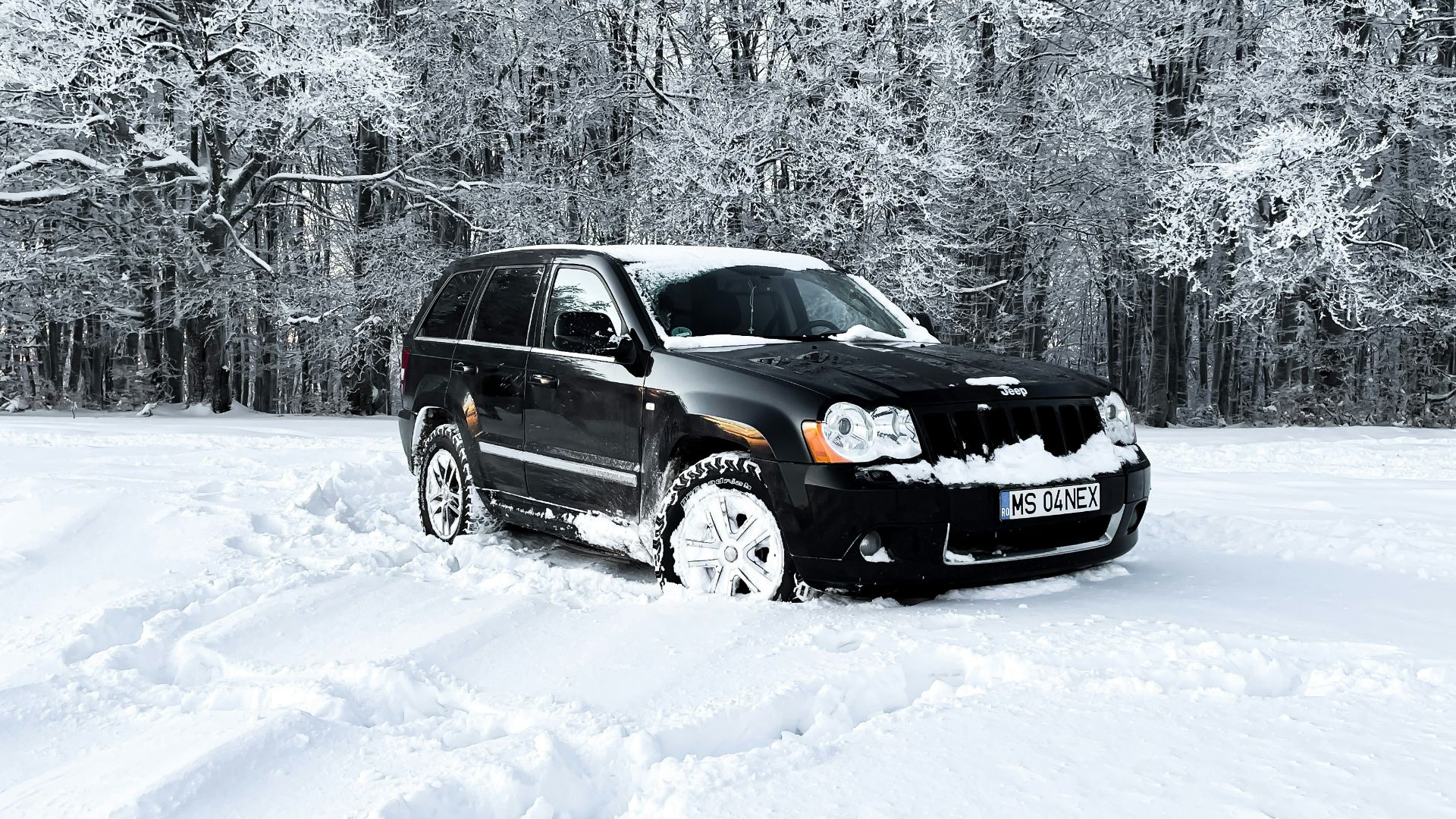 a black car is parked in the snow