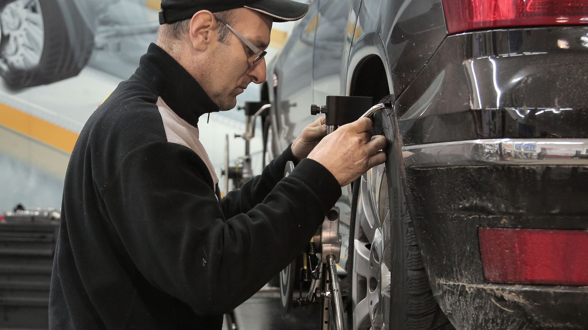 Professional mechanic adjusting wheel alignment for optimal performance in auto repair shop.