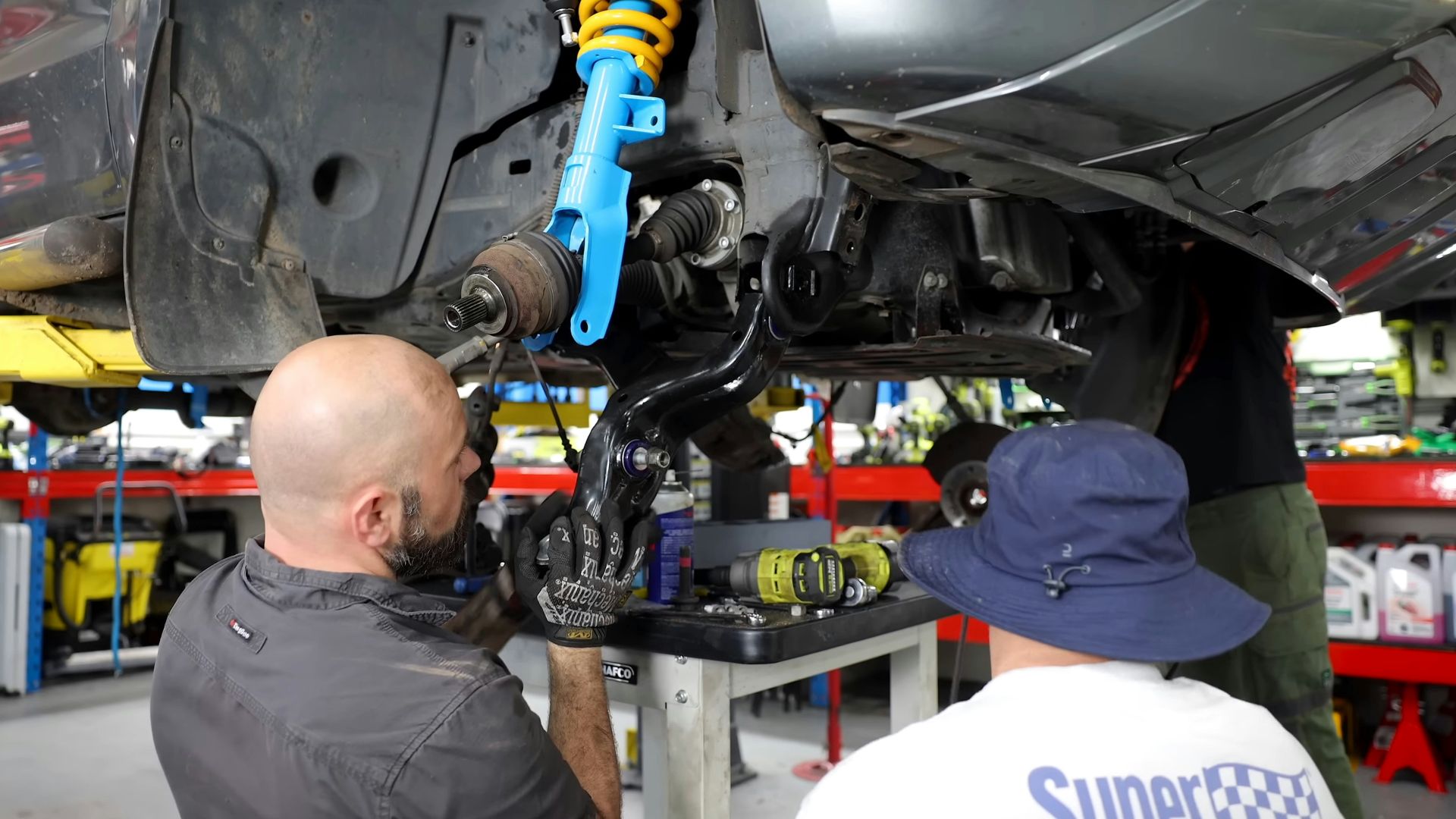 Two men working on a car in a garage