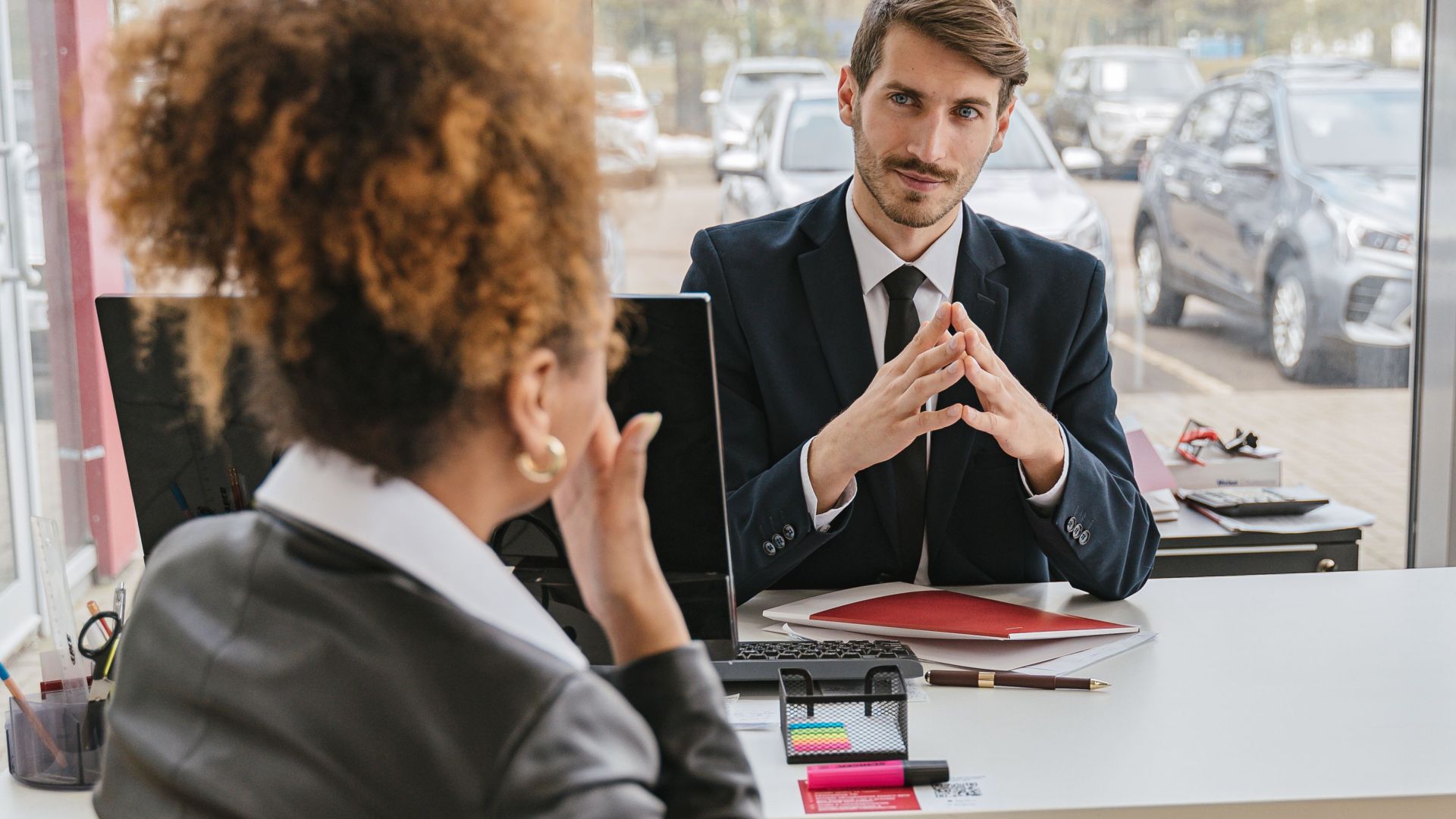 Business professionals engaged in conversation at a modern office desk, discussing ideas and strategies.