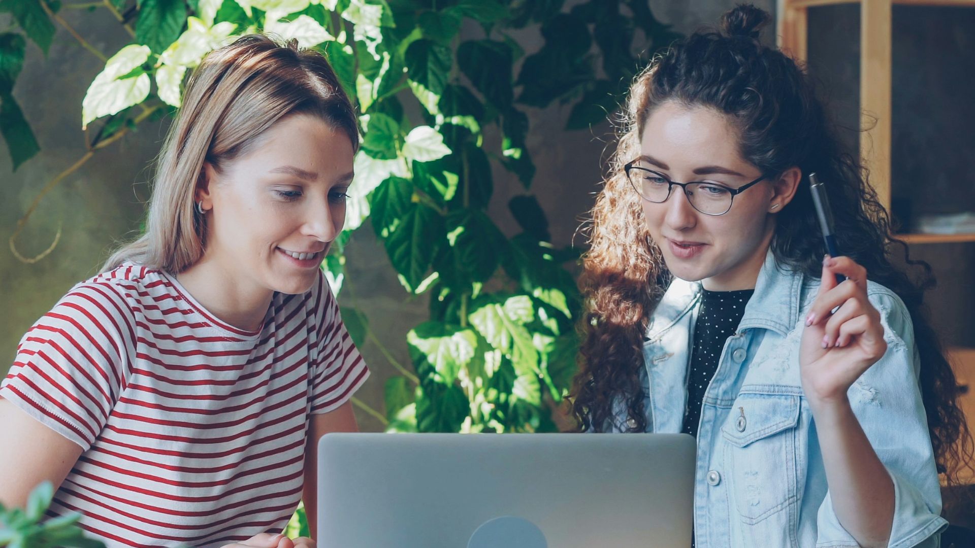 Two women collaborate at a laptop together