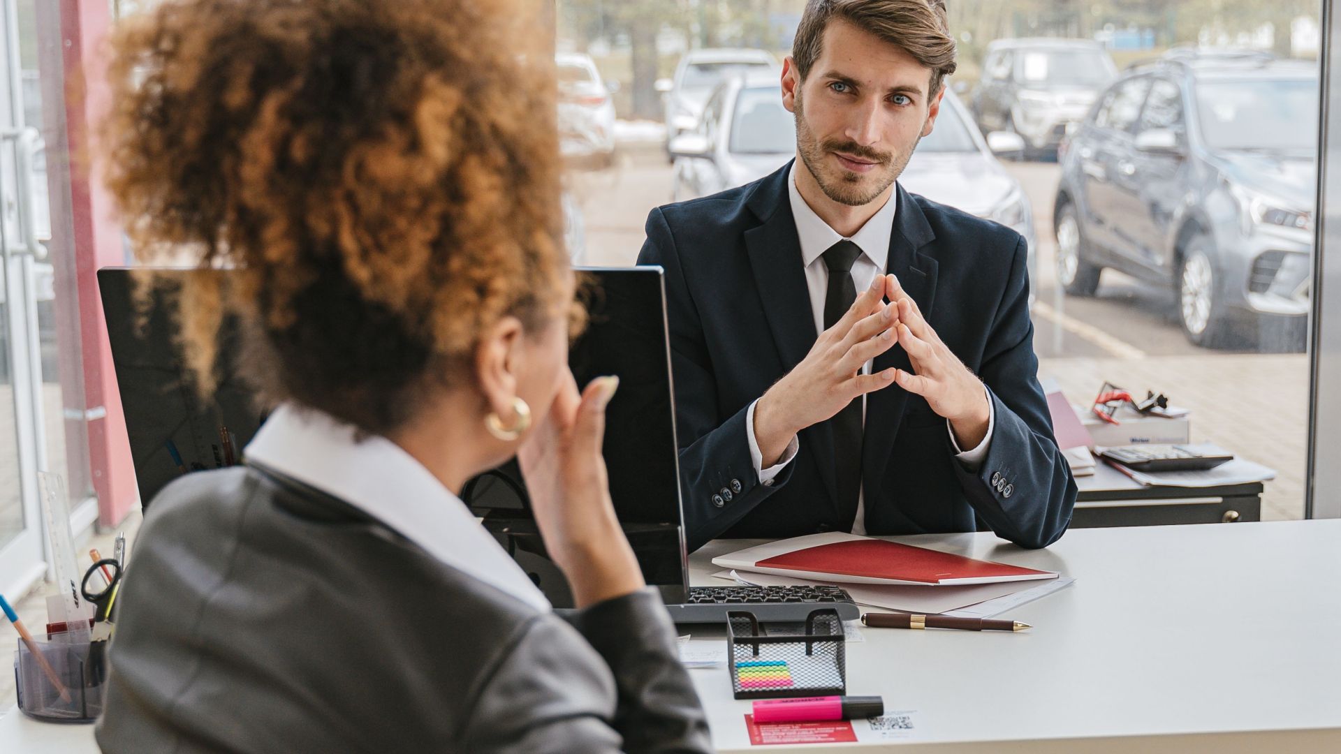 Business professionals engaged in conversation at a modern office desk, discussing ideas and strategies.