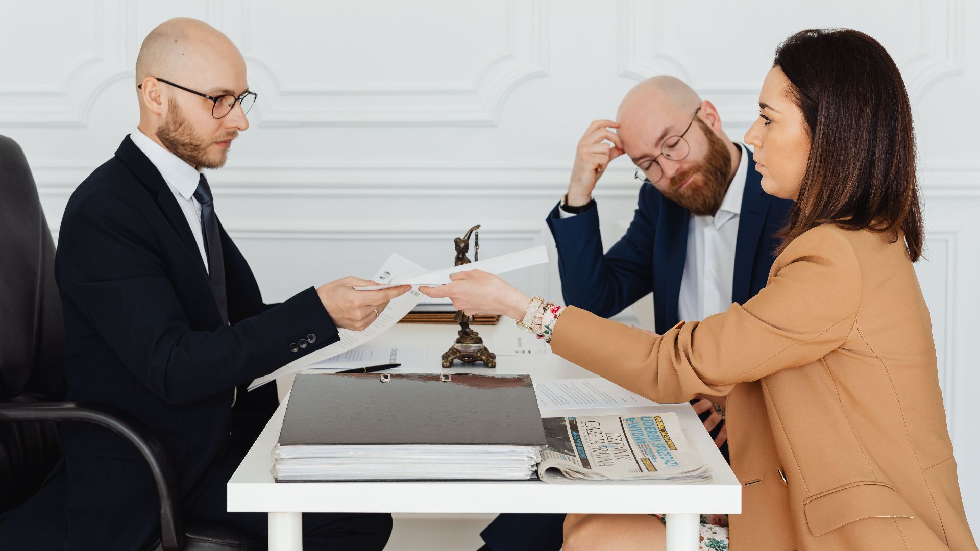 Professional meeting with lawyer and clients discussing documents in a modern office.