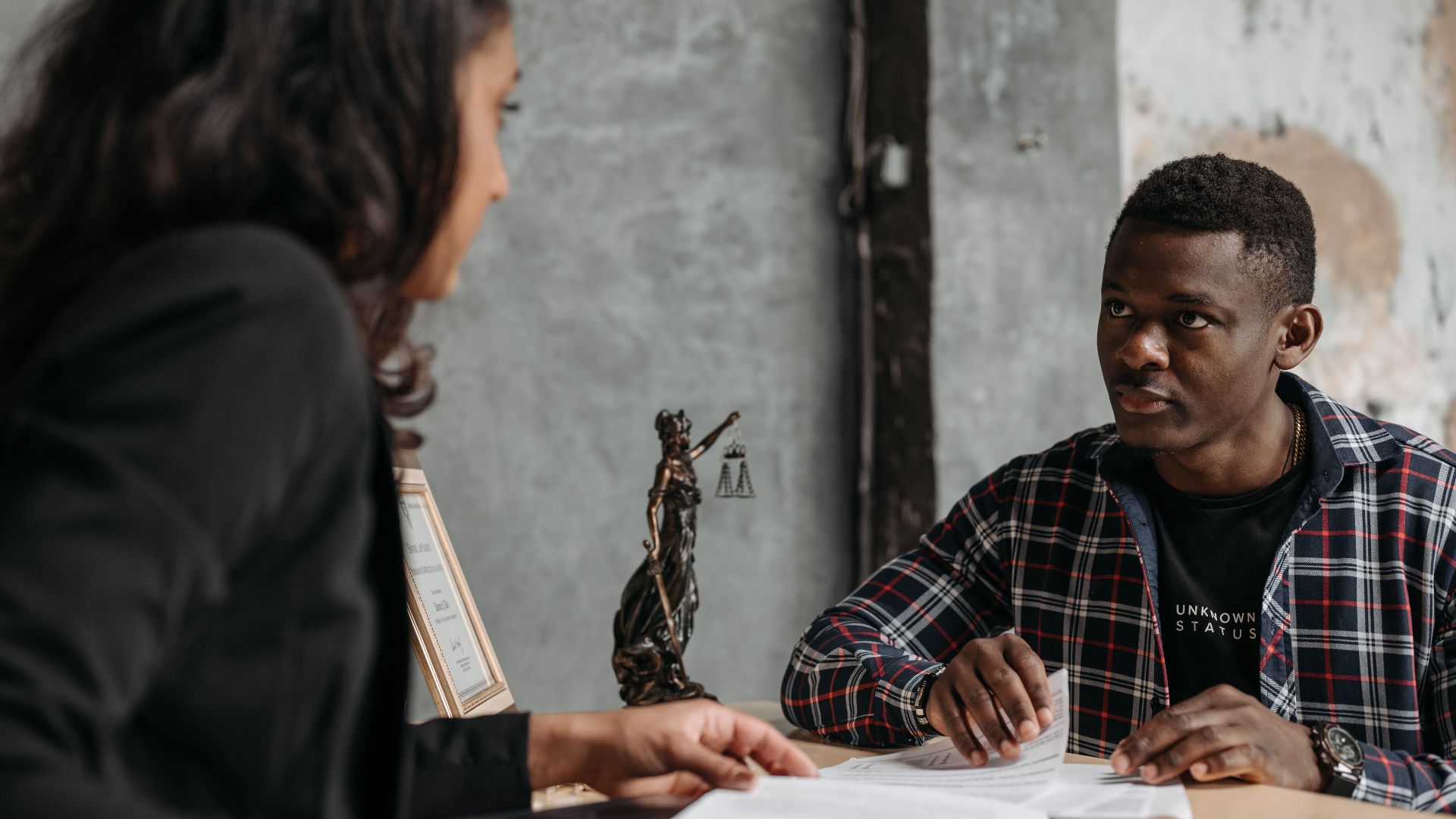 Business meeting between a lawyer and client in a professional office setting.