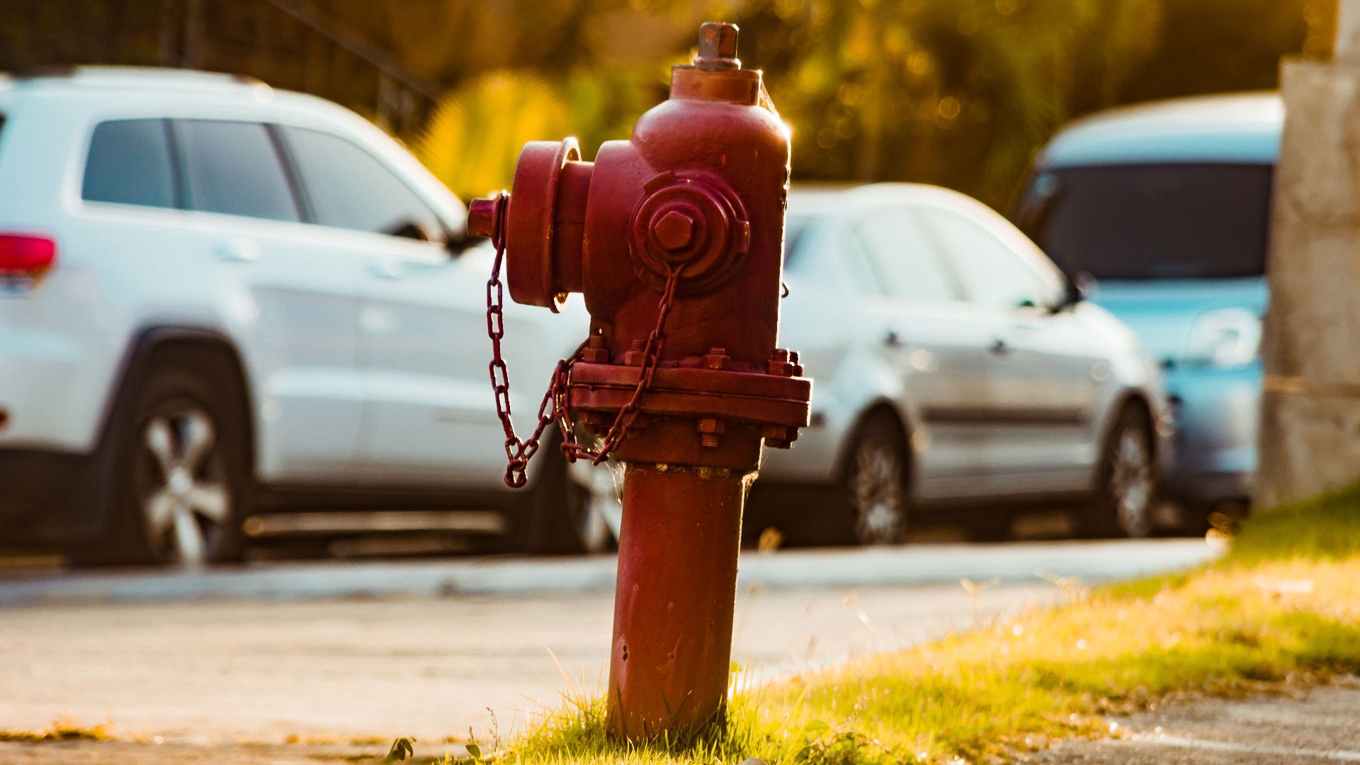 Red fire hydrant on a Santo Domingo street with parked cars.