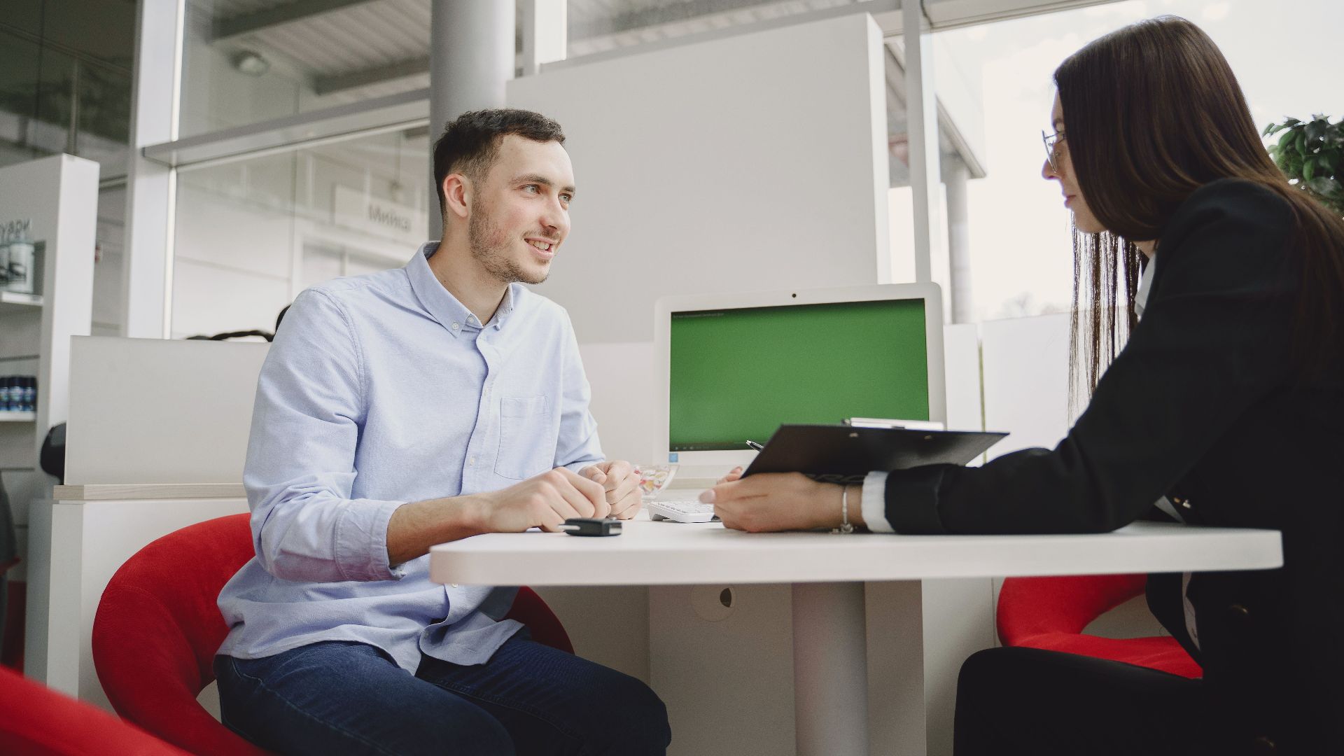 A man and woman engaged in a professional meeting at a modern office table.