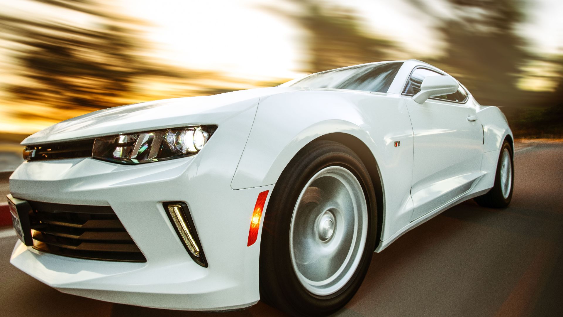 A white sportscar in motion showcasing speed and style on an open road.