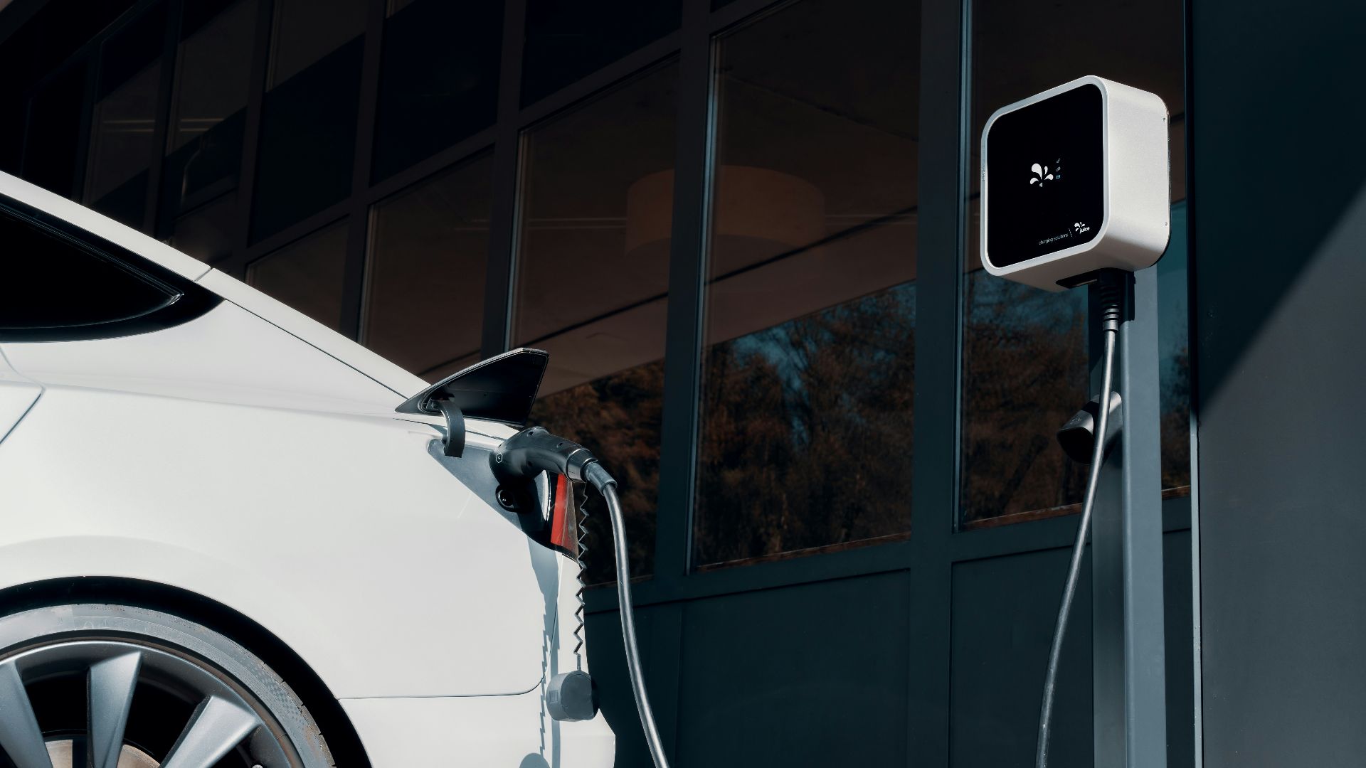 a white car plugged in to a charging station