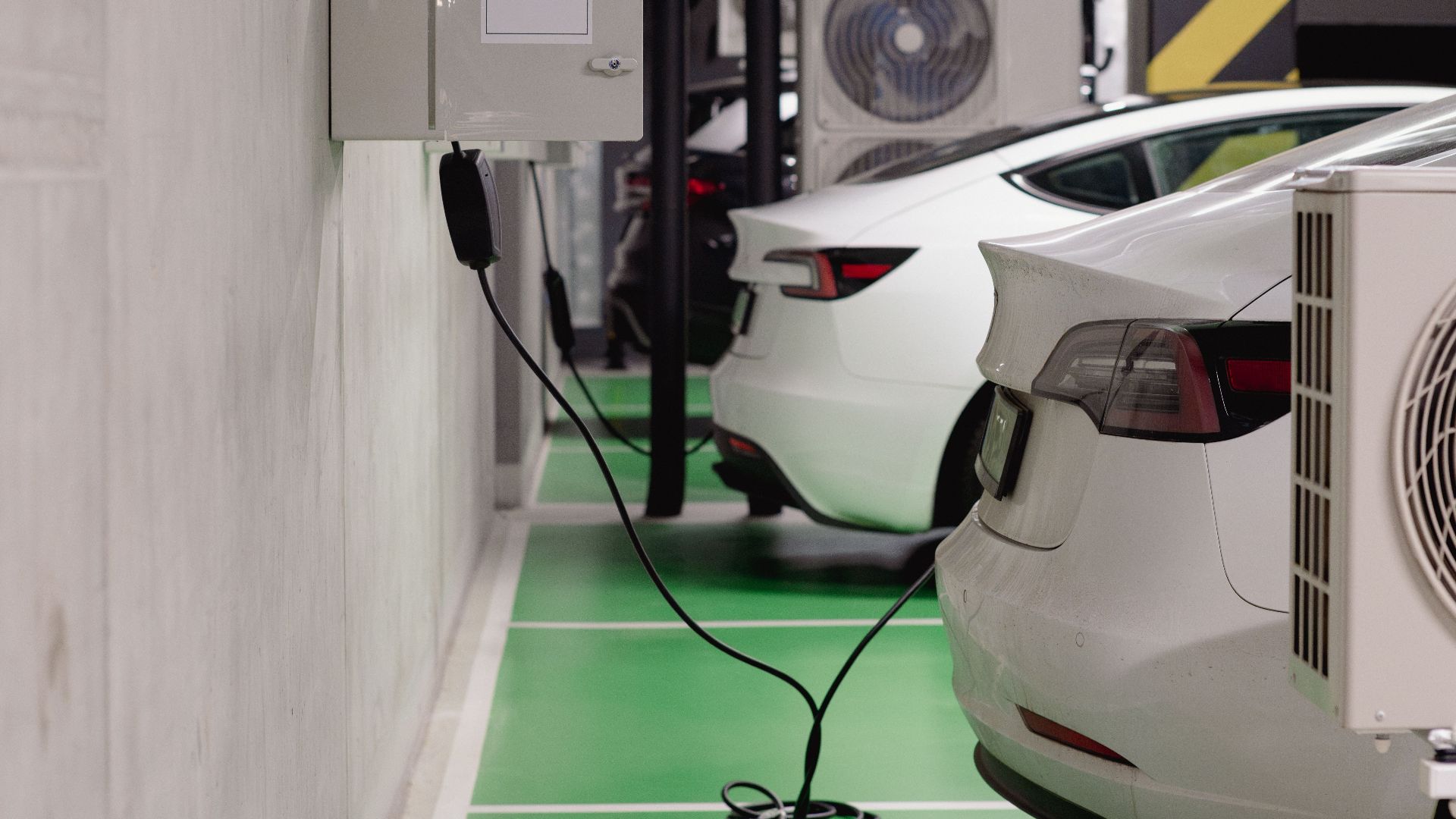 Electric vehicles charging at an indoor station in a modern underground garage.