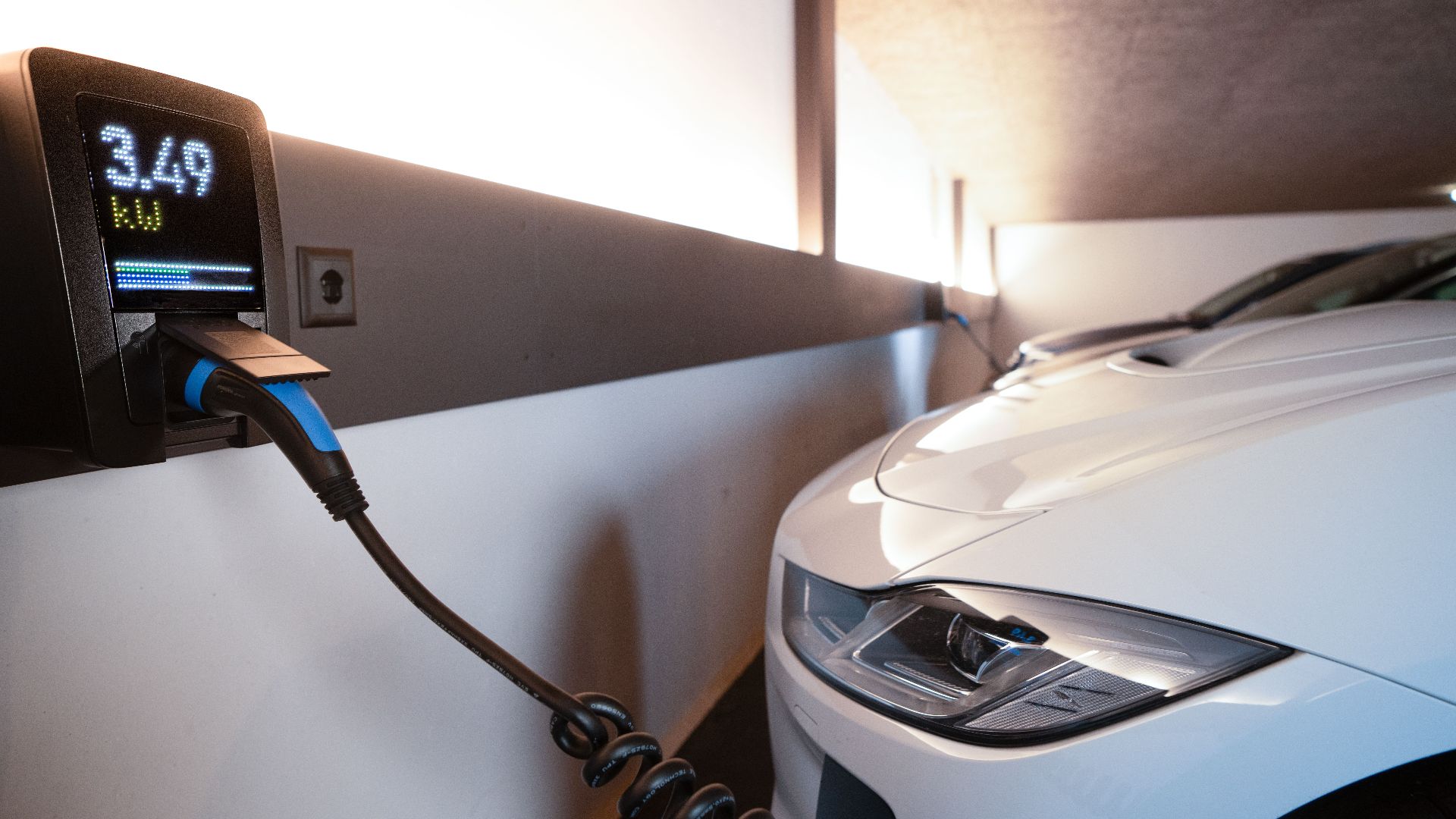 White electric car charging at indoor station, emphasizing sustainability and efficiency.