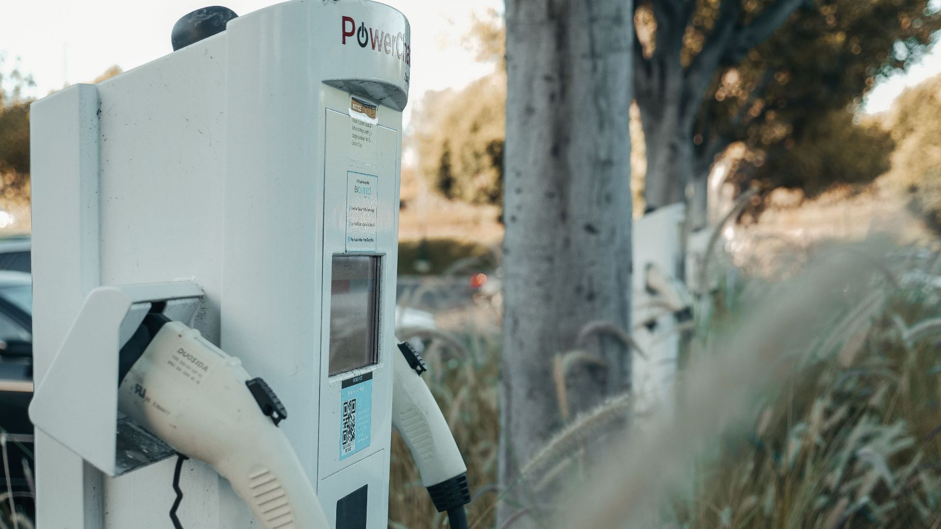 Electric vehicle charging station in an outdoor natural setting, highlighting sustainable technology.