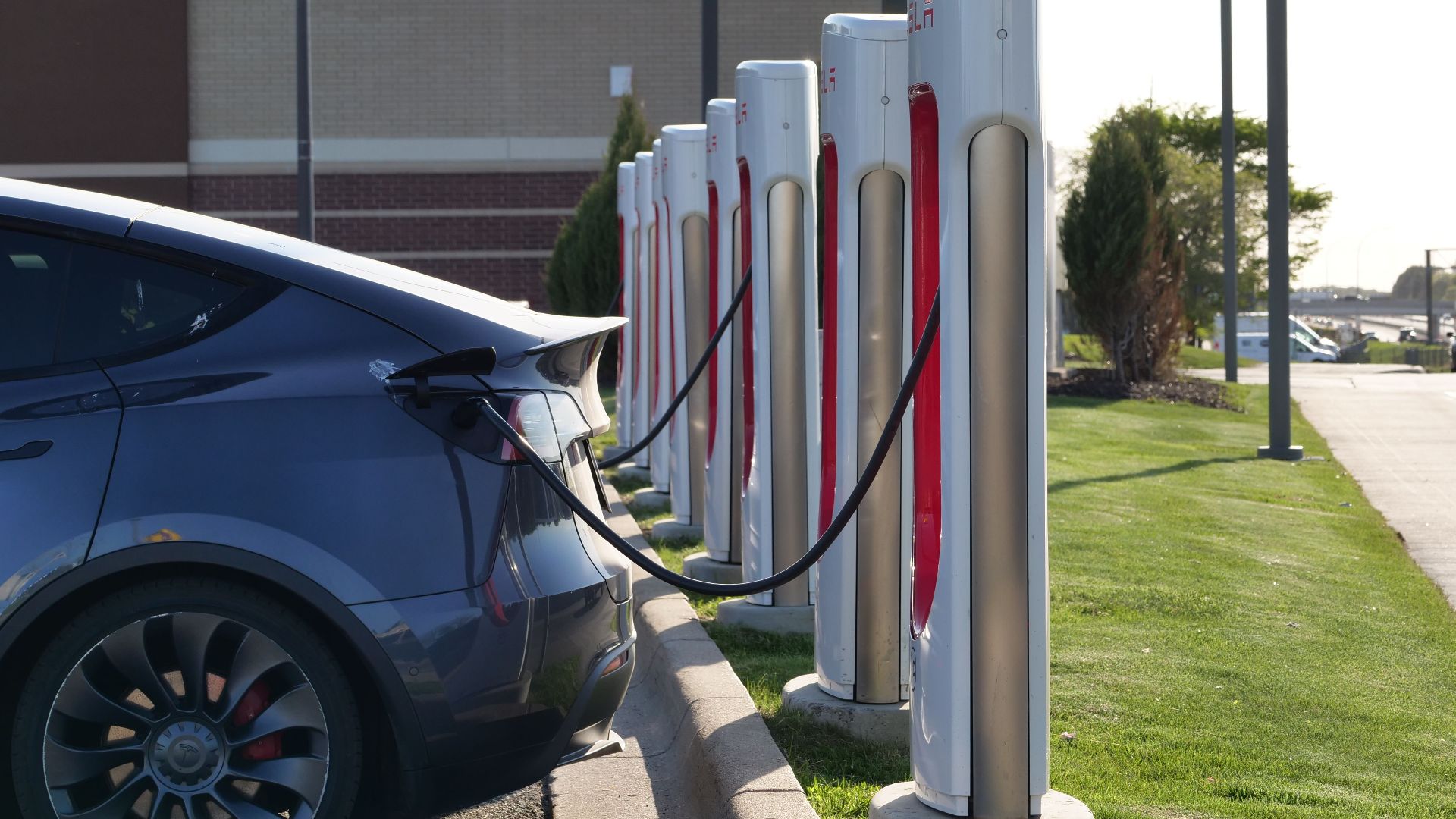 Electric car plugged into a row of charging stations, showcasing modern EV infrastructure.
