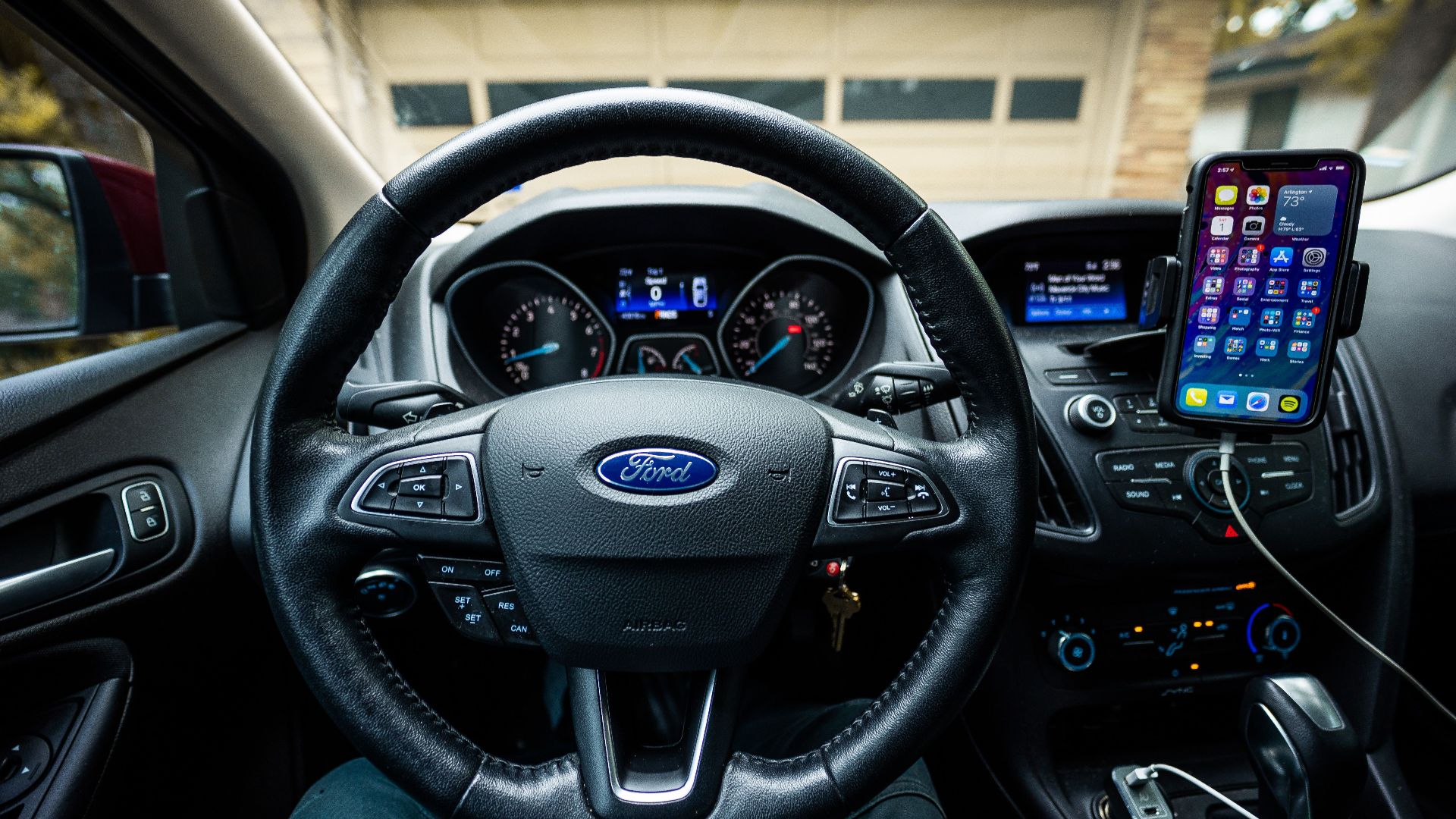 Interior view of a Ford car featuring a steering wheel, dashboard, and mobile device mount.