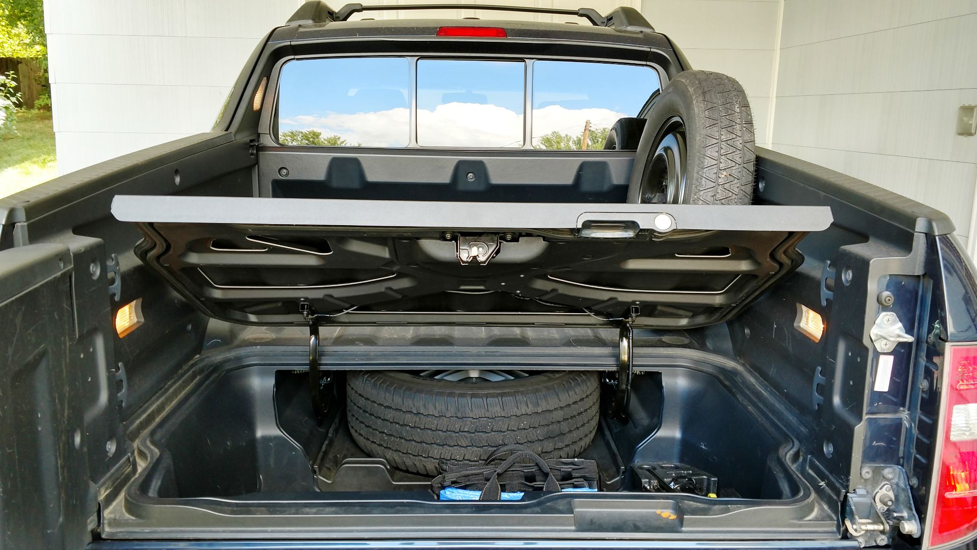 2006-2014 Honda Ridgeline with full-size spare tire in spare tire service tray and temporary tire mounted on bed wall mount