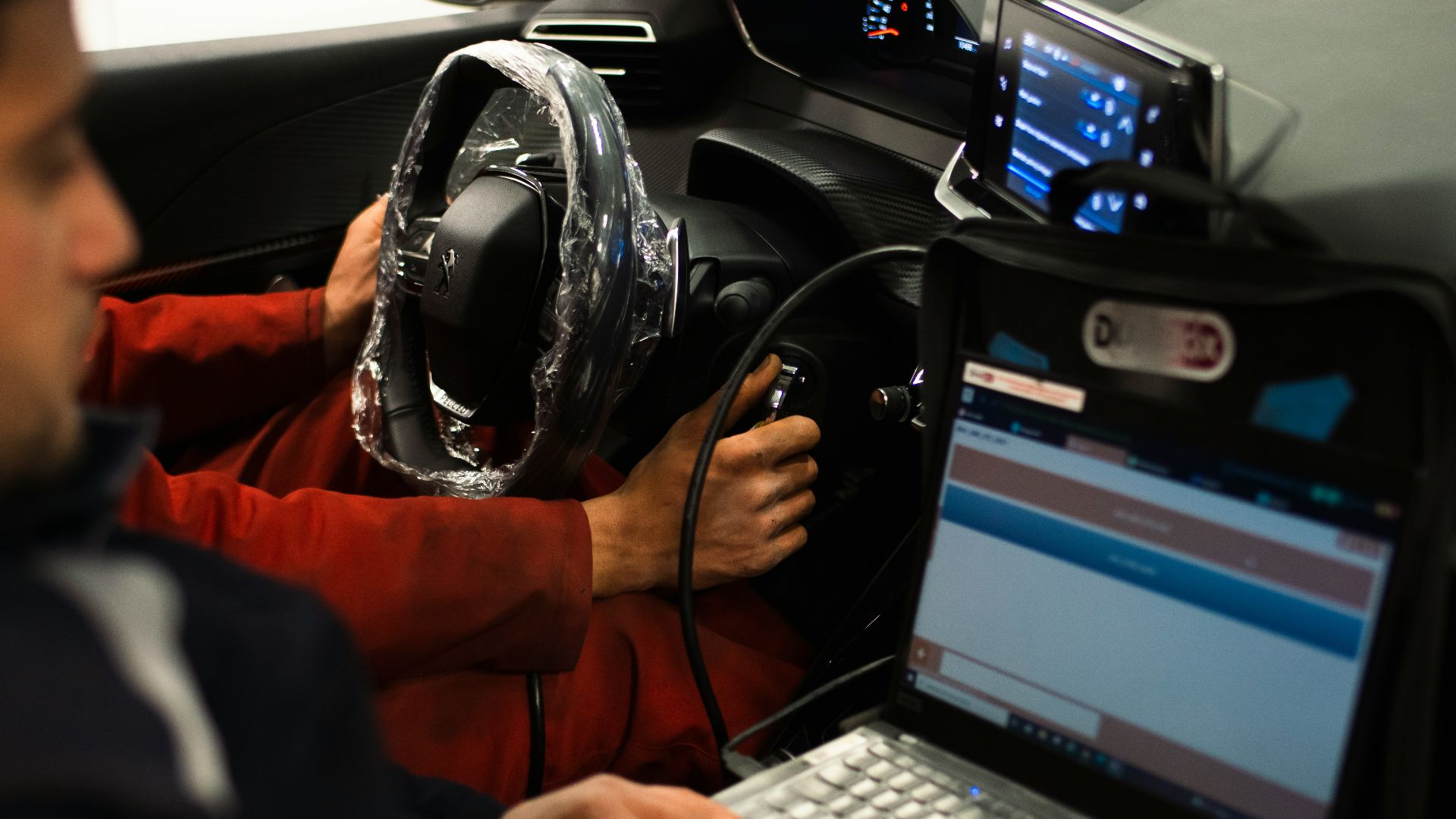 A man sitting in a car using a laptop computer
