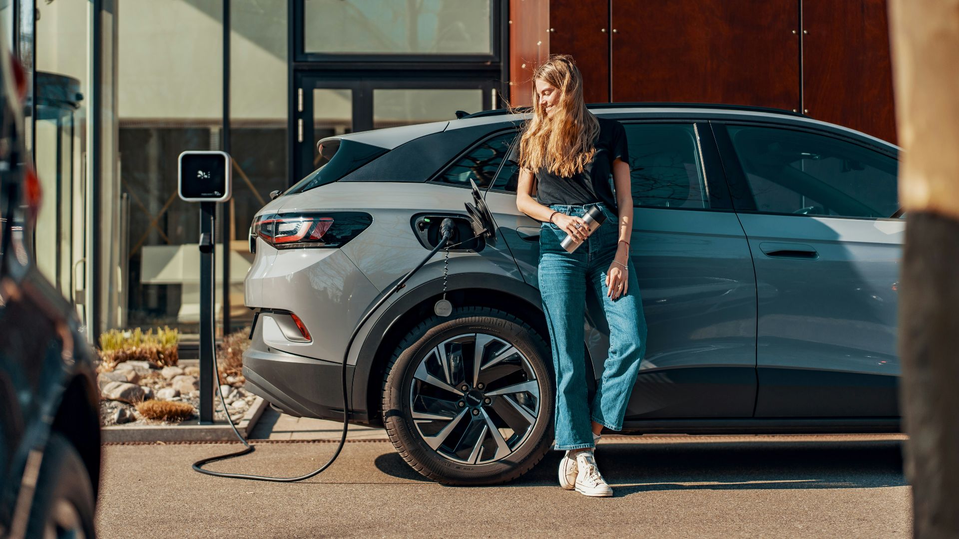 a woman standing next to a blue car