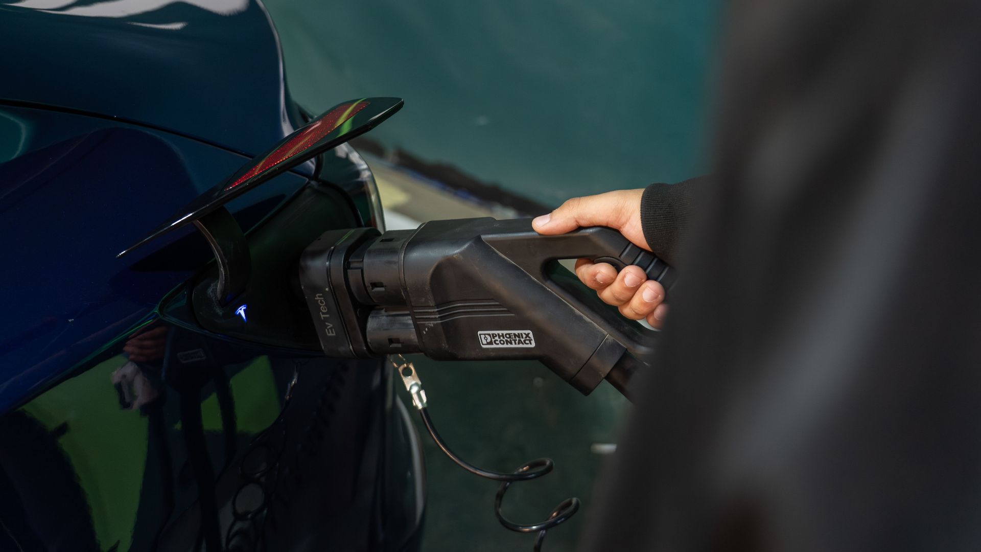 Close-up of an electric vehicle being charged at a station.