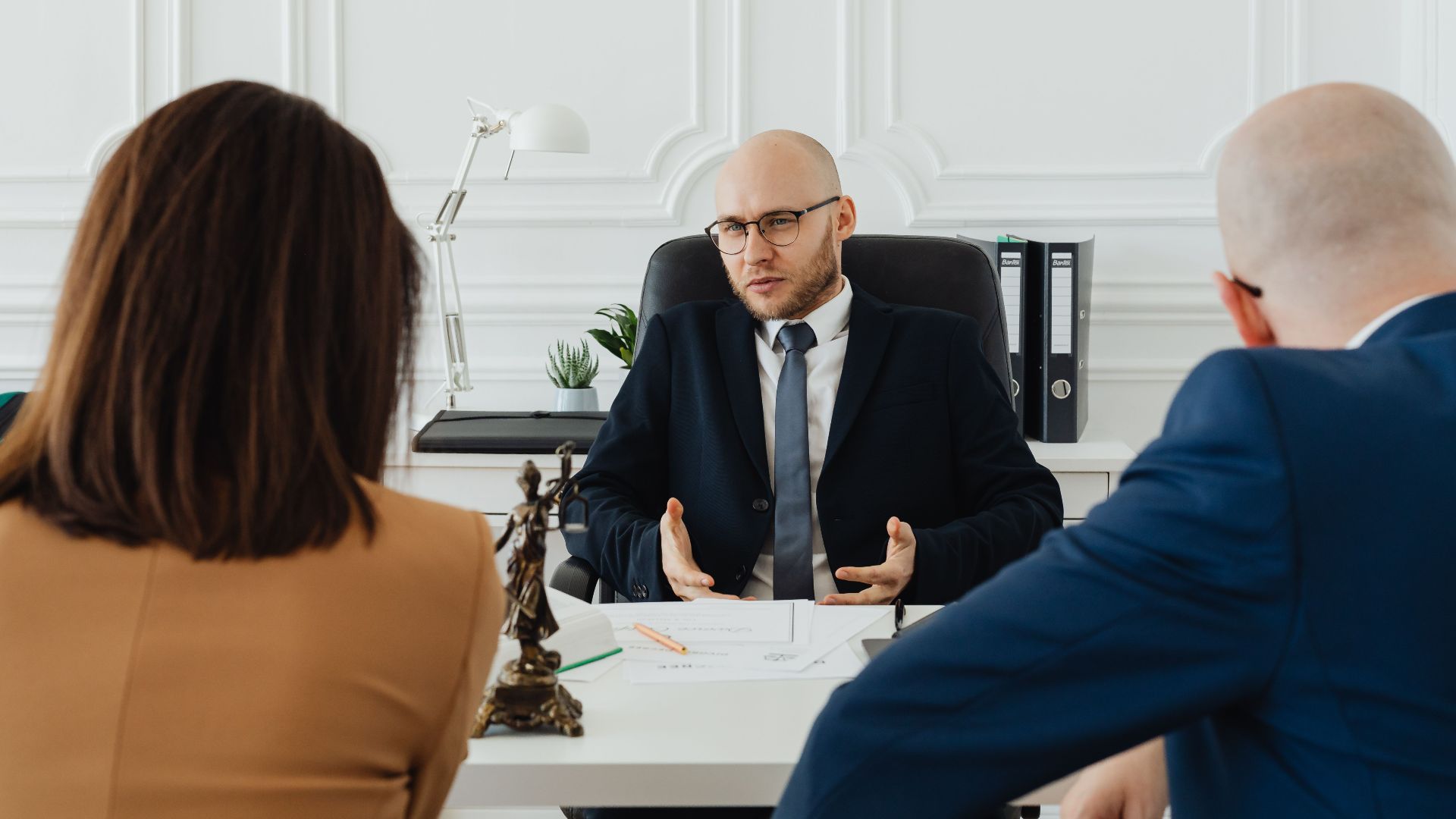 A professional business meeting with a lawyer and clients in a modern office setting.