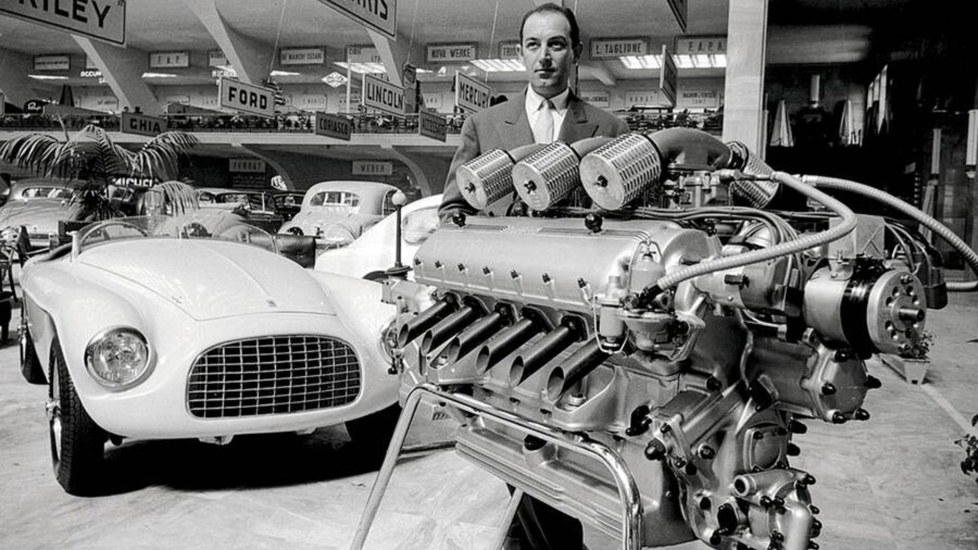 Aurelio Lampredi and his V12 engine at 1951 Torino show.  Behind is a Ferrari 212 Export.