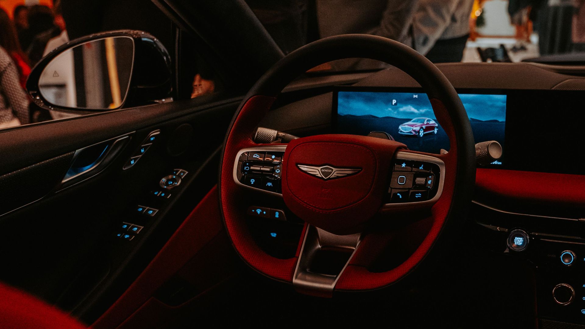 View of a luxury car interior with sleek red upholstery and modern dashboard design.