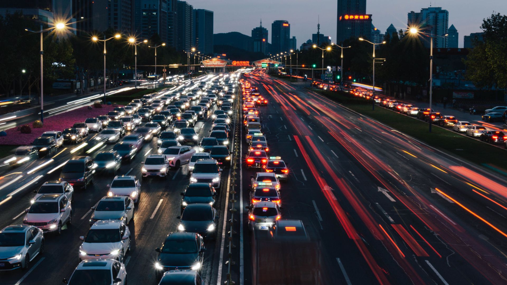 Busy city highway during rush hour with stunning light trails and skyscrapers.