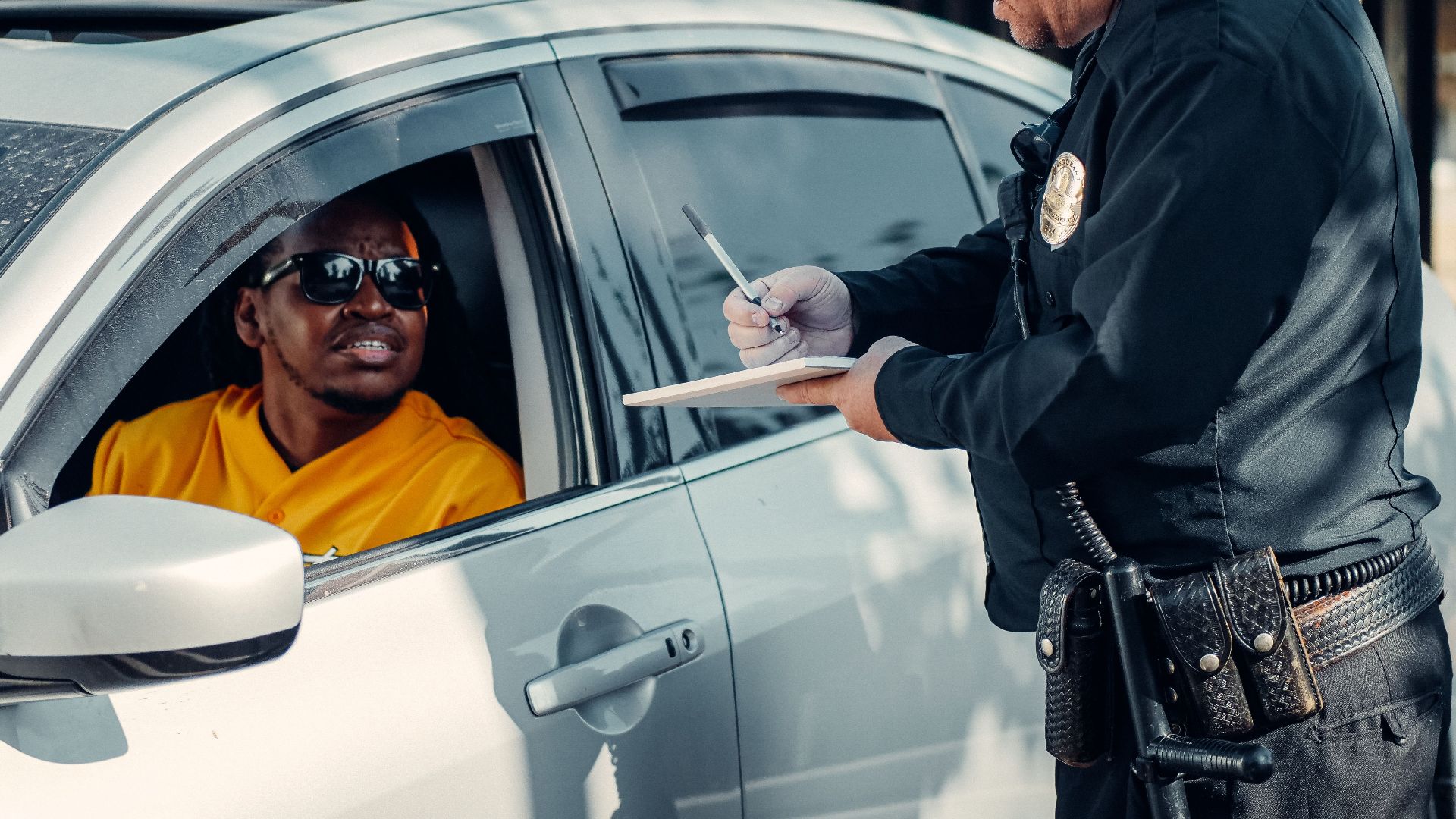Police officer writes a traffic ticket for a driver during a routine stop.