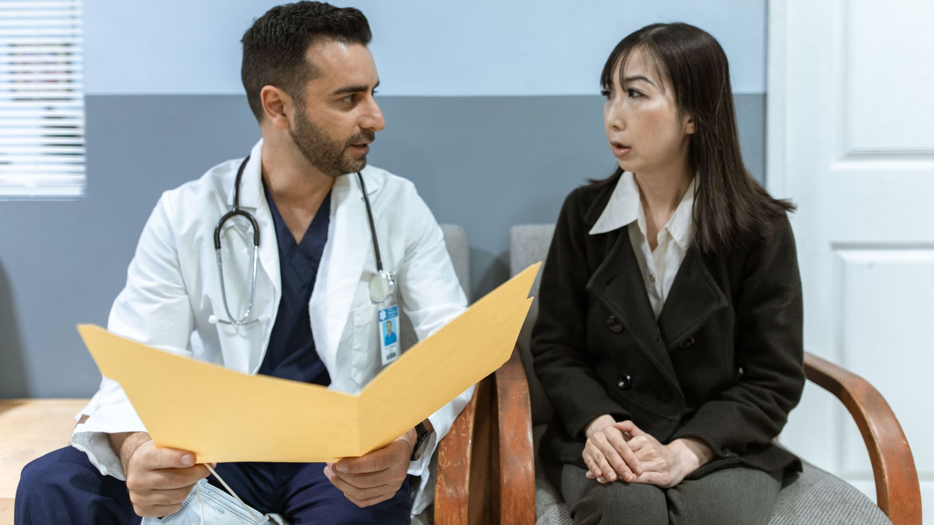 Healthcare professional consults patient in clinical setting. Medical discussion and diagnosis.