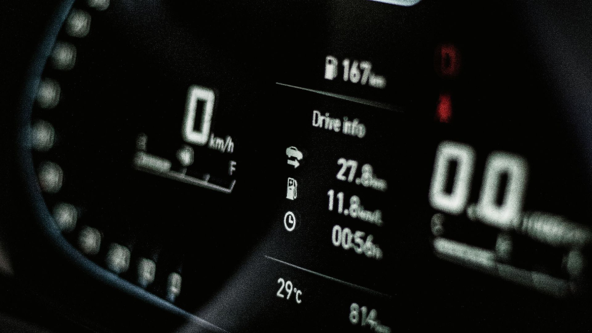 Close-up of a sleek digital car dashboard displaying speed and drive info.