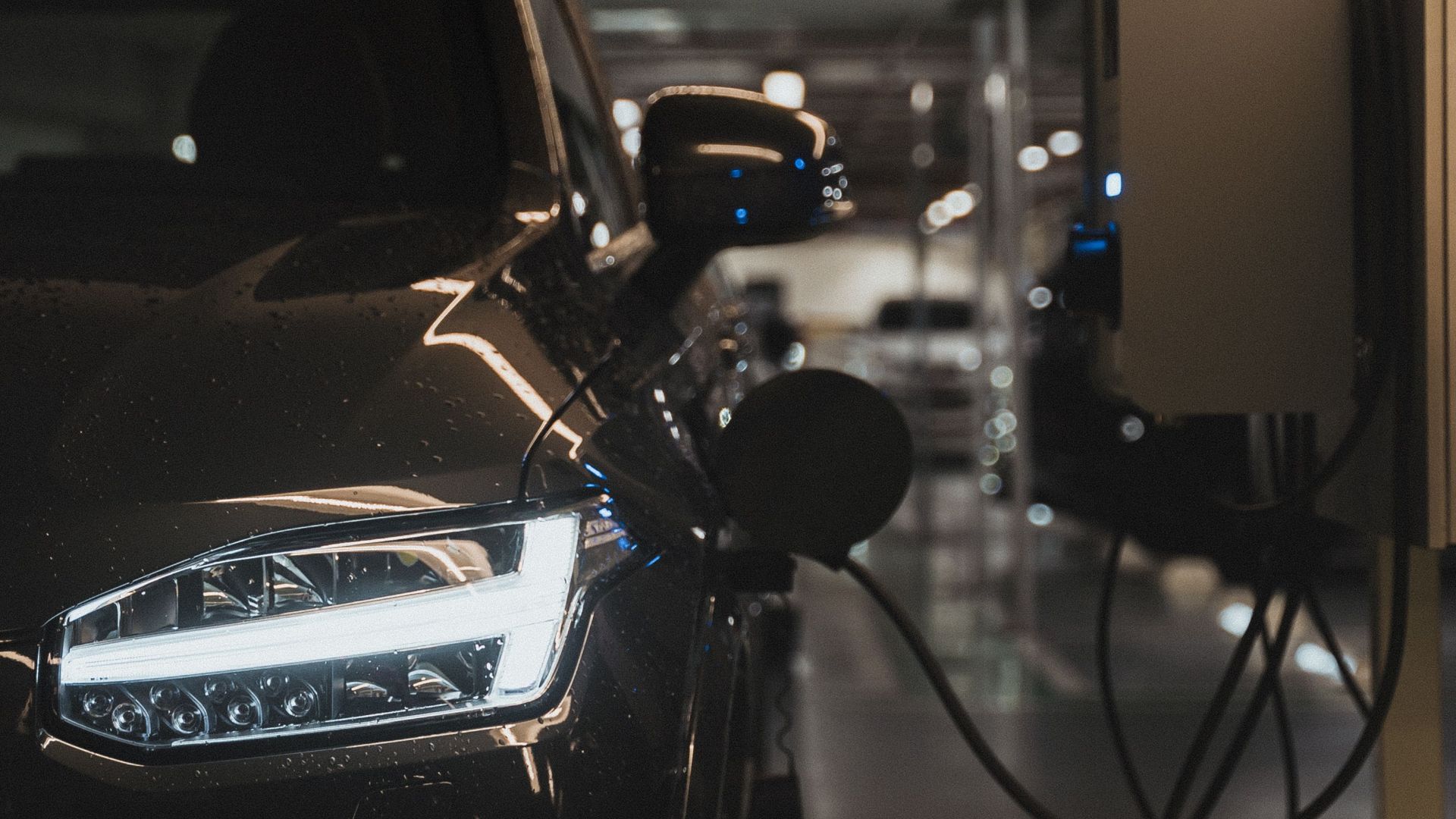Luxury electric car charging at a station in Curitiba parking garage.
