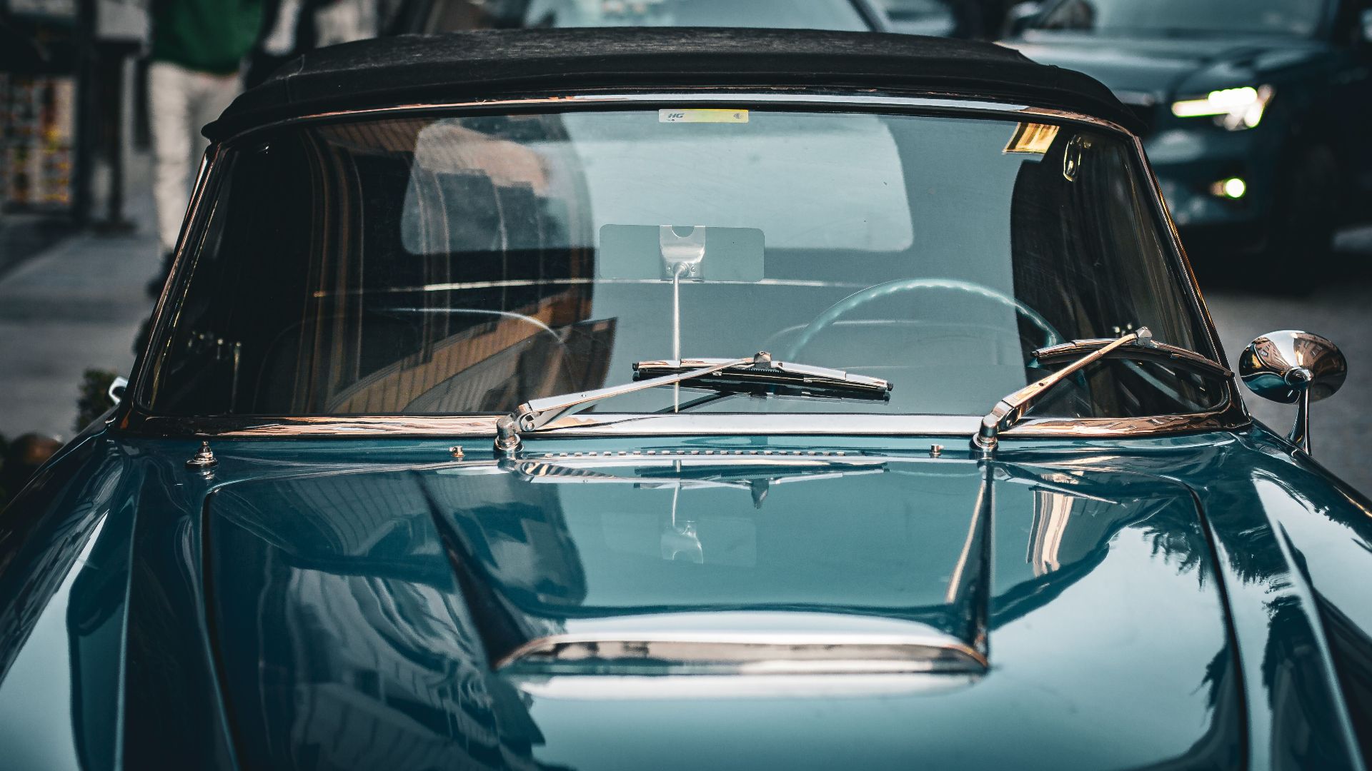 A stylish blue vintage convertible parked on a busy urban street depicting retro elegance.